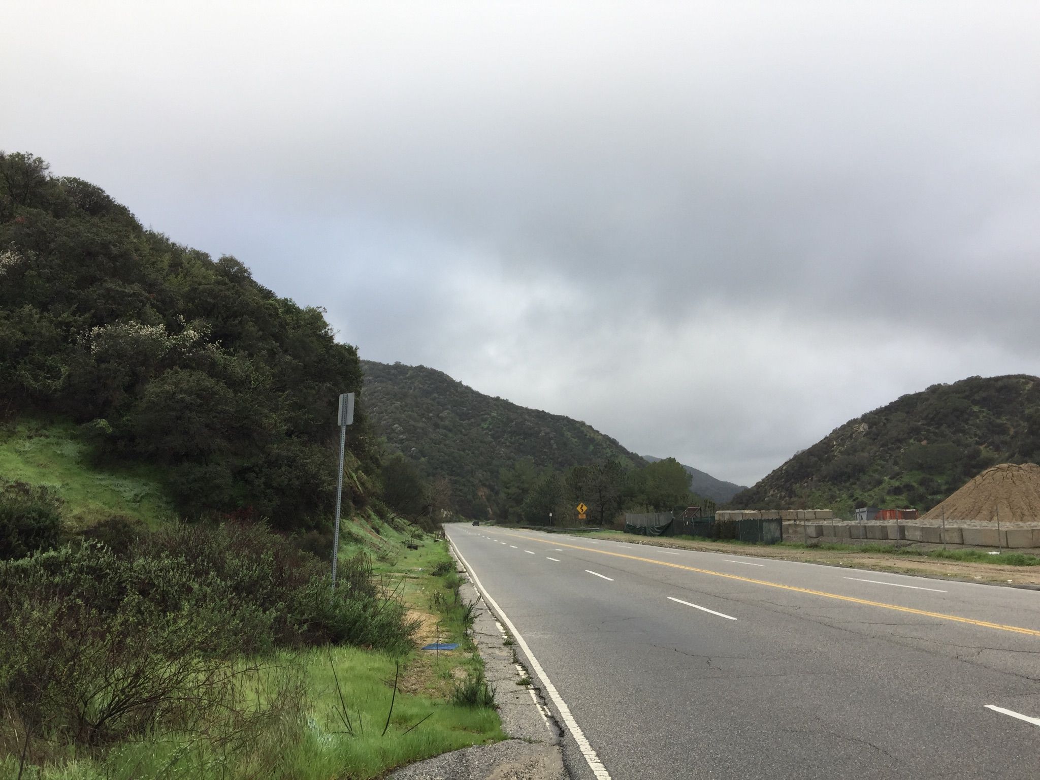 Empty highway winding through green hills under a cloudy sky. - La Tuna Canyon Road – Miradero Gate loop from Downtown Burbank