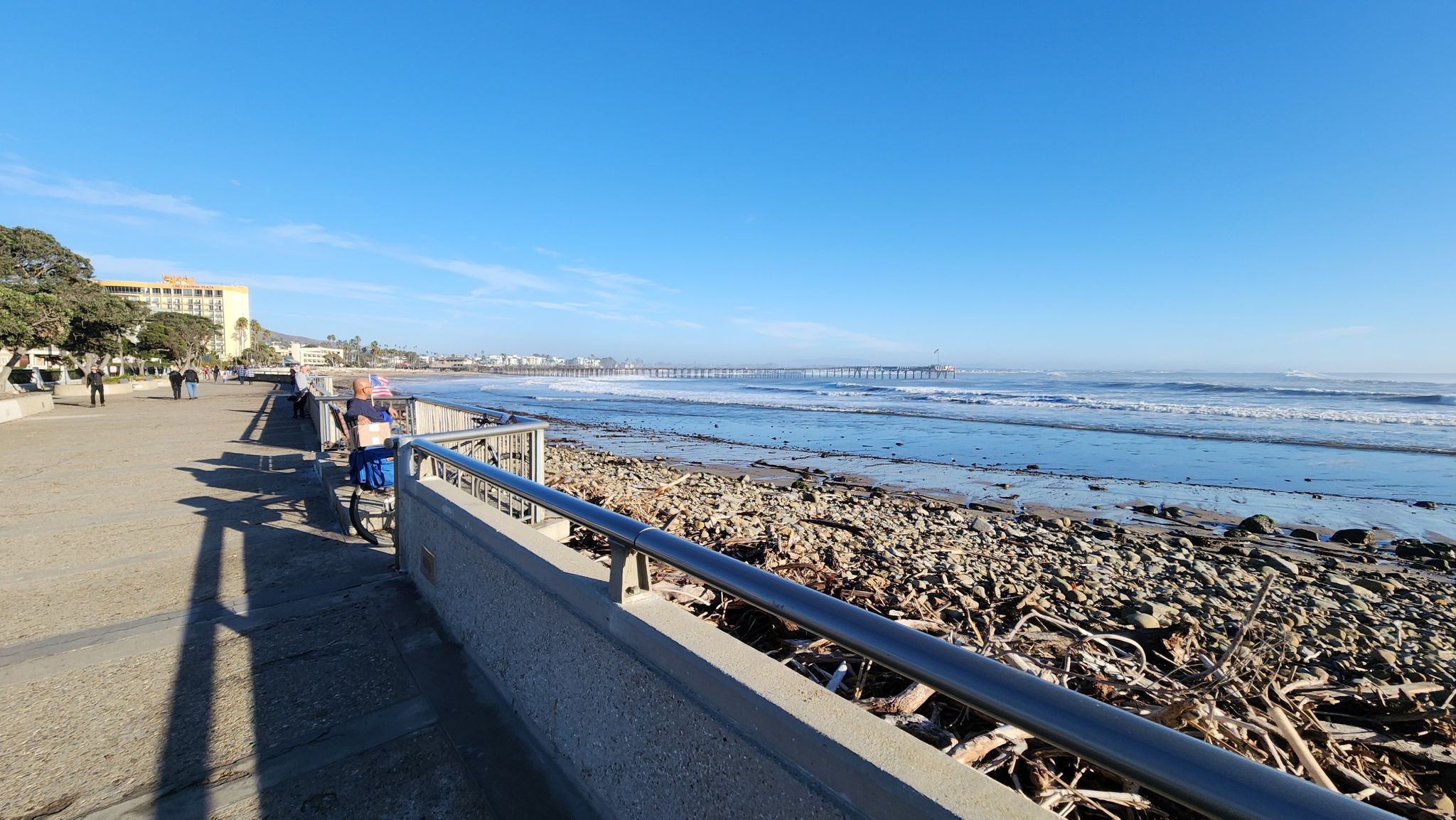 Paved promenade by rocky beach and ocean with waves, people walking. - Ventura Pier – Surfers Point Beach loop from Ventura