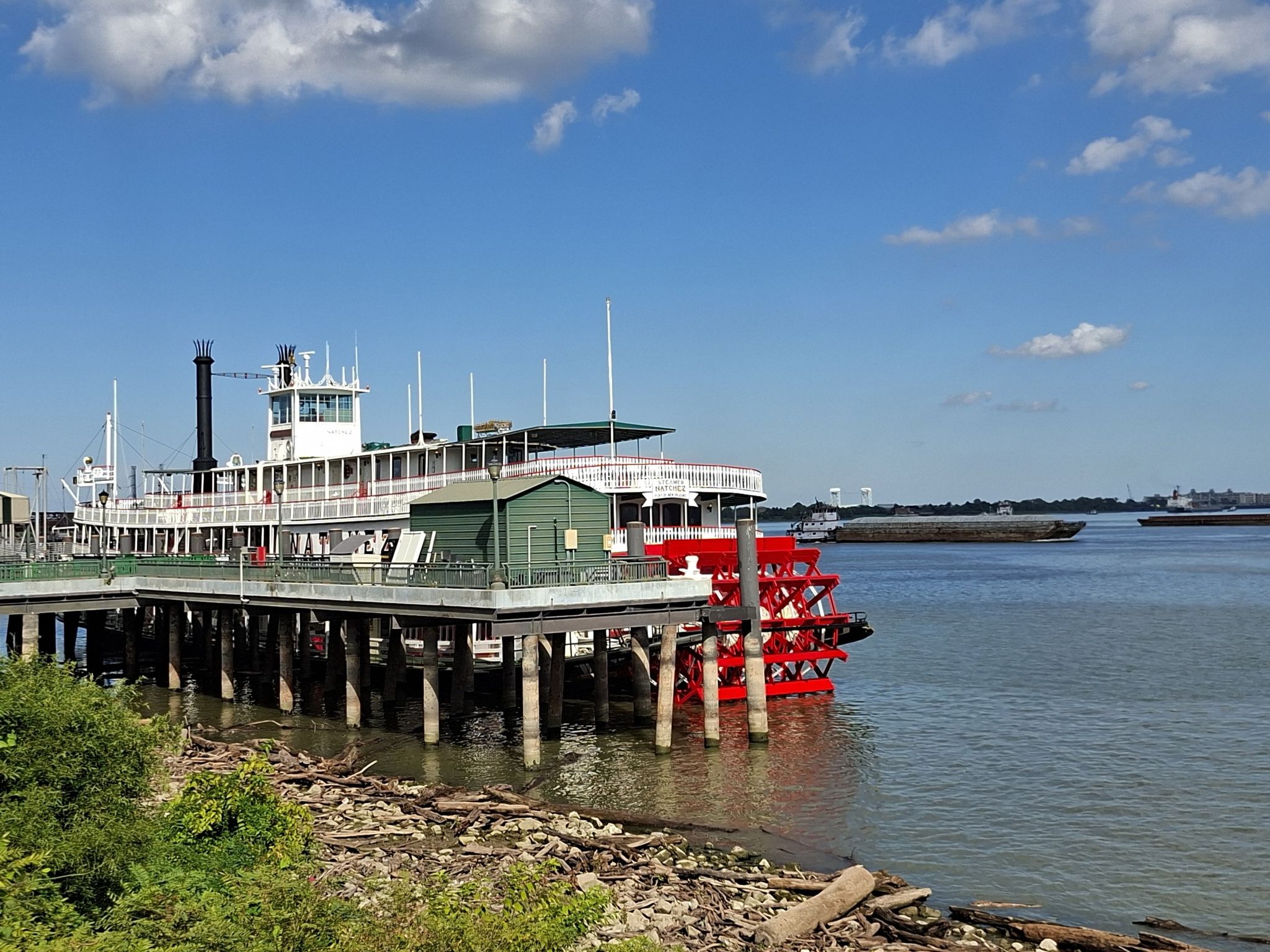Paddlewheel boat docked at a pier on a sunny day with blue sky. - Royal Street, New Orleans – Steamboat Natchez loop from New Orleans