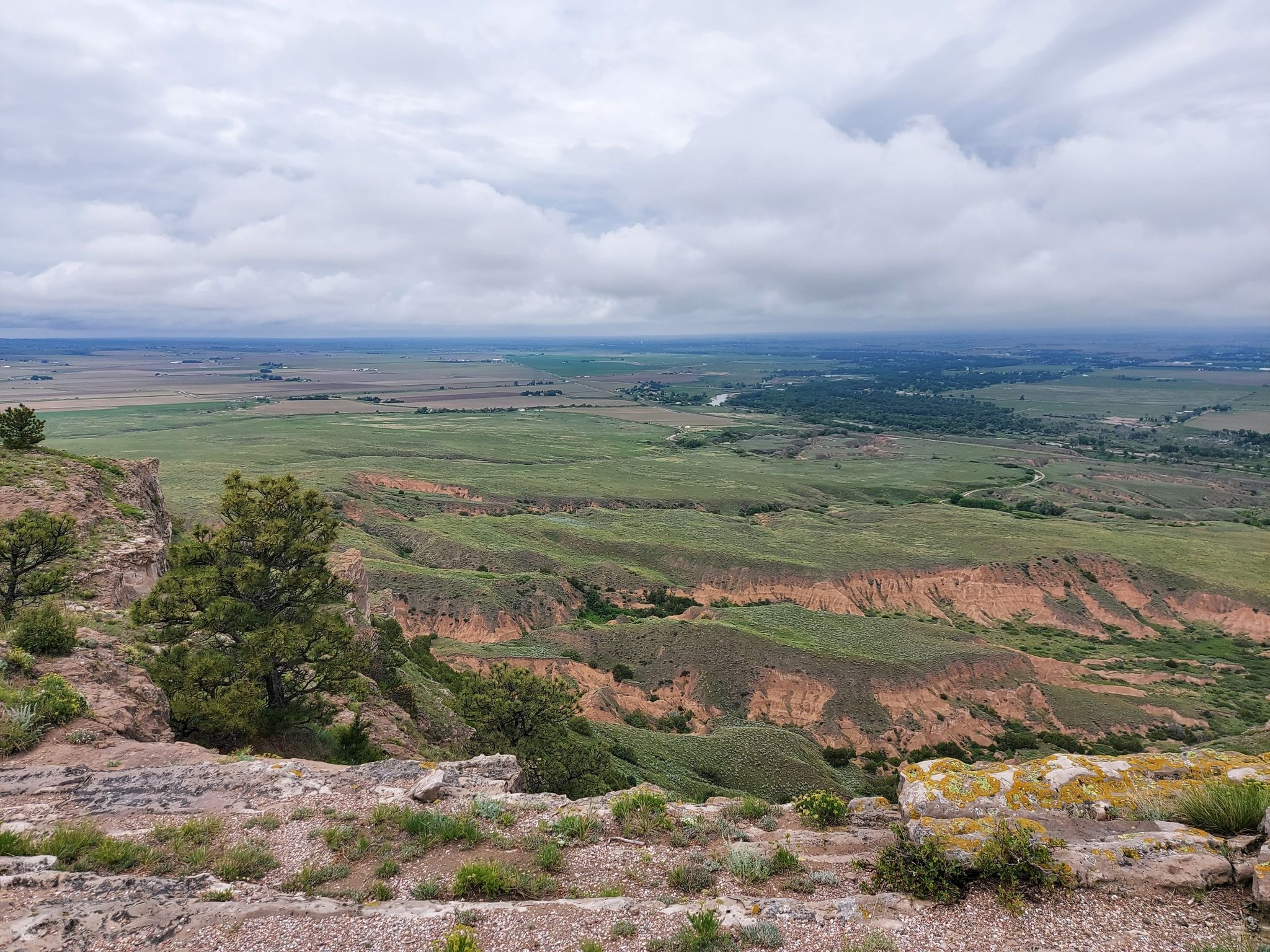 Expansive view of green and red-tinged hills stretching to a distant horizon. - North Overlook Trail