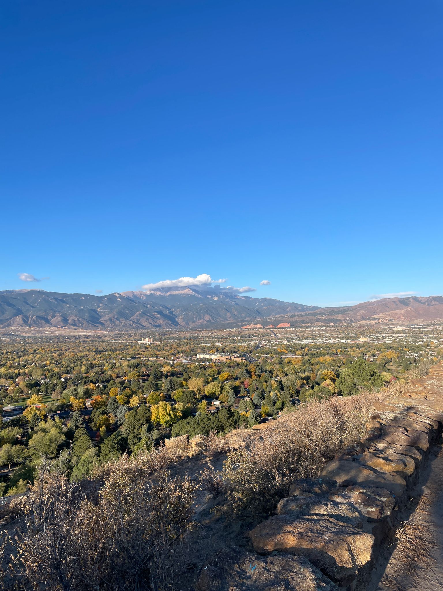 Overlook of a valley with autumn trees and distant mountains under a clear sky. - South East of Colorado Springs Loop