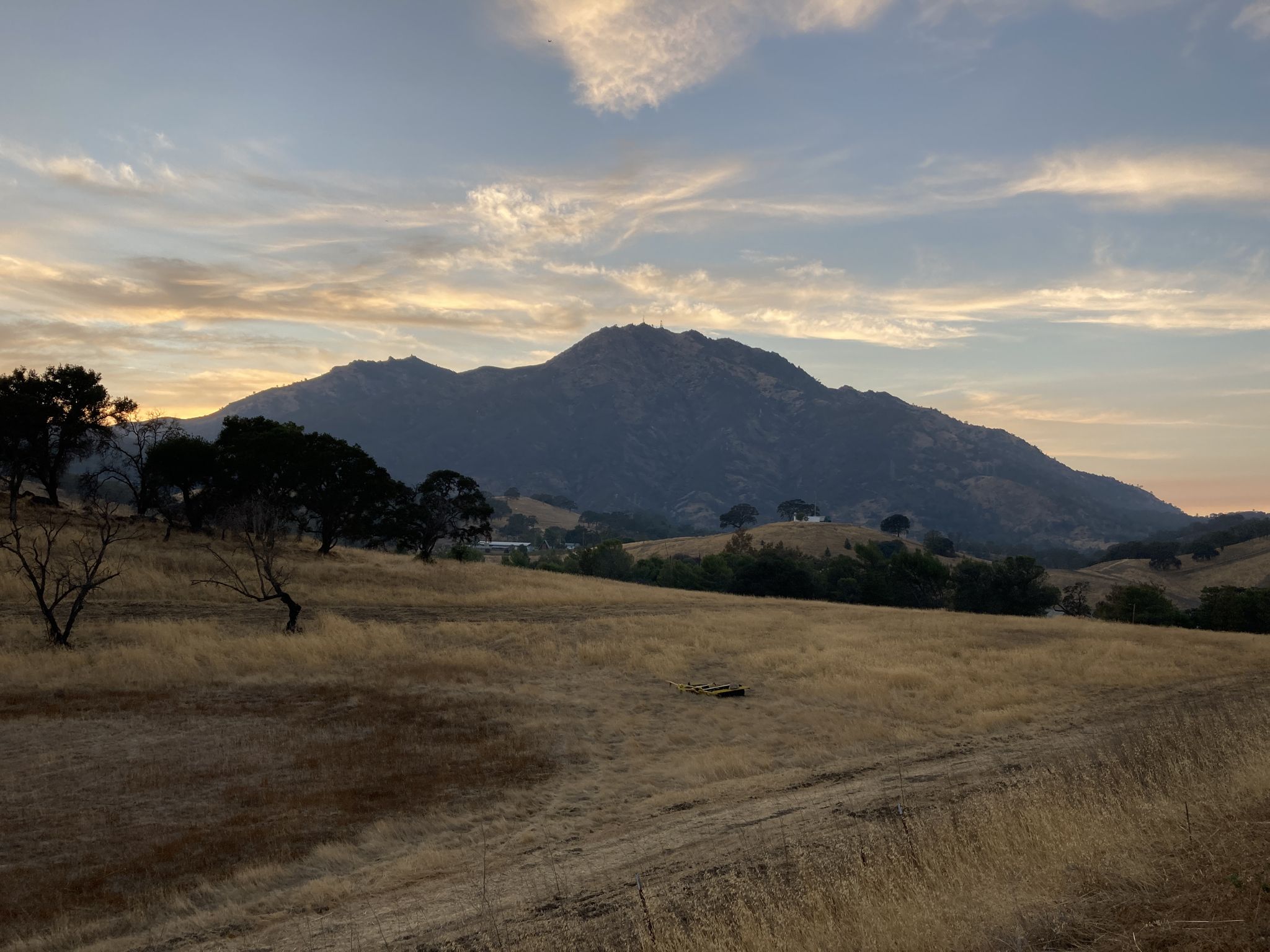 Majestic mountain overlooking a dry field at sunset with cloudy sky. - Clayton Ranch loop