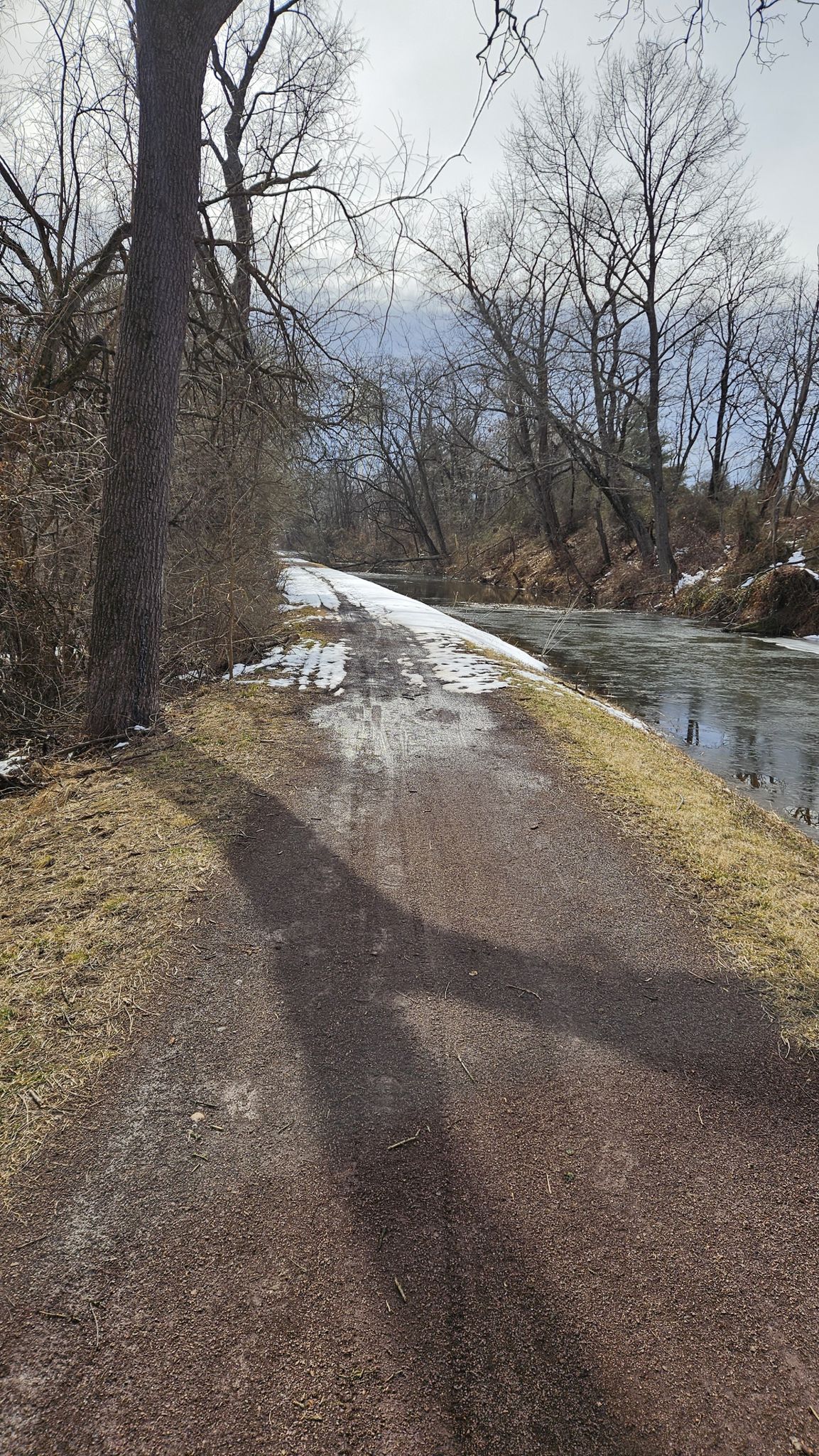 A dirt path alongside a partially frozen canal with bare trees in winter. - View from Scudder Falls Bridge – Canal Bridge to the 1799 House loop from Bristol