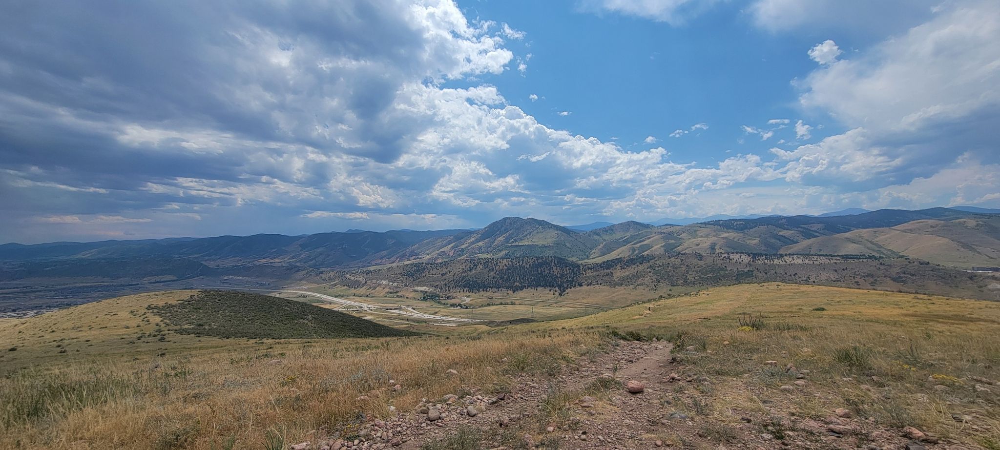 Vast mountain landscape with a dirt path under a partly cloudy sky. - Hayden Trail Junction – Green Mountain Peak loop from Green Mountain High School