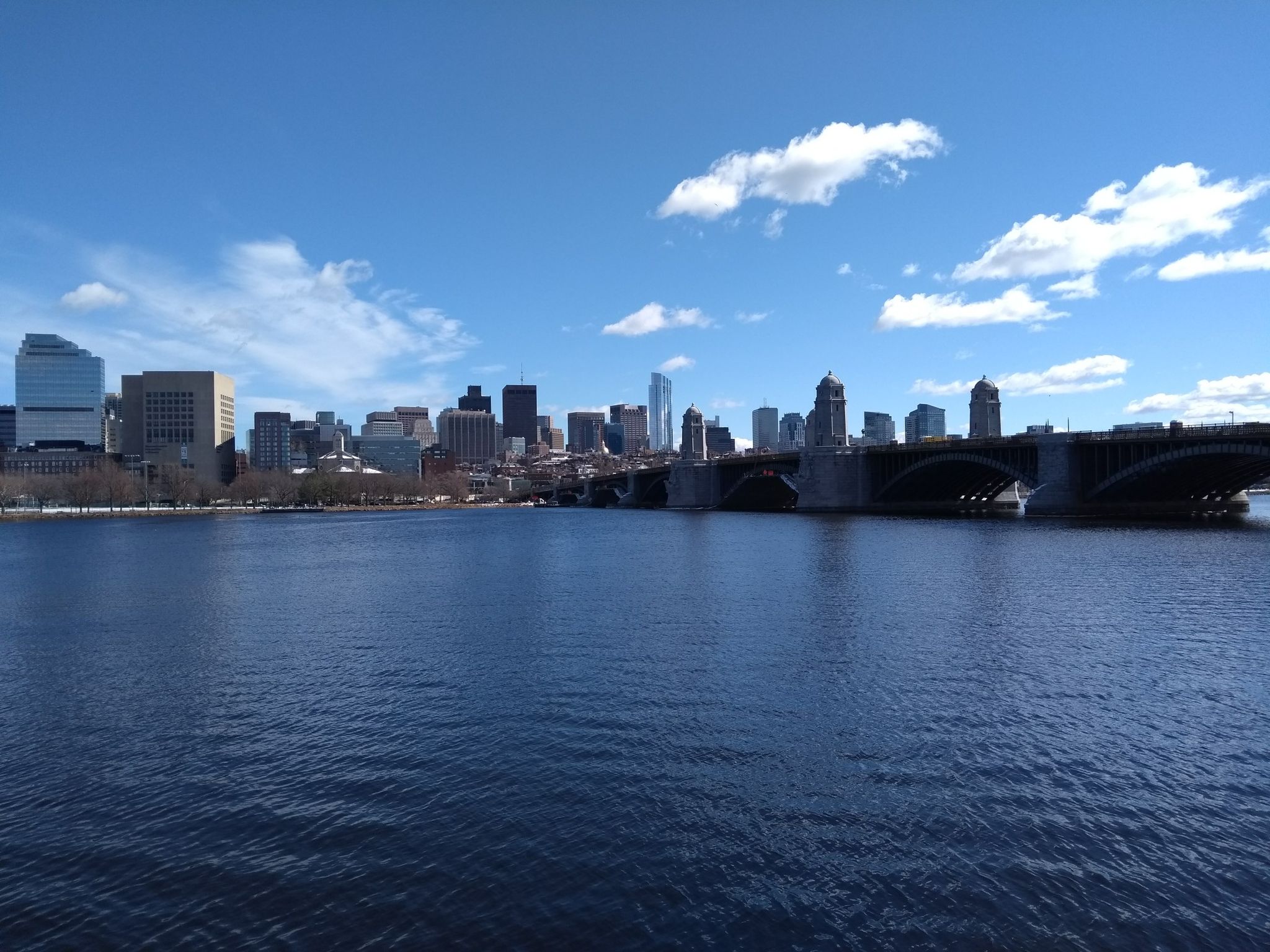 Bright sunny day over a wide river with a city skyline and large bridge. - Charles River and Charlestown Harborwalk Loop