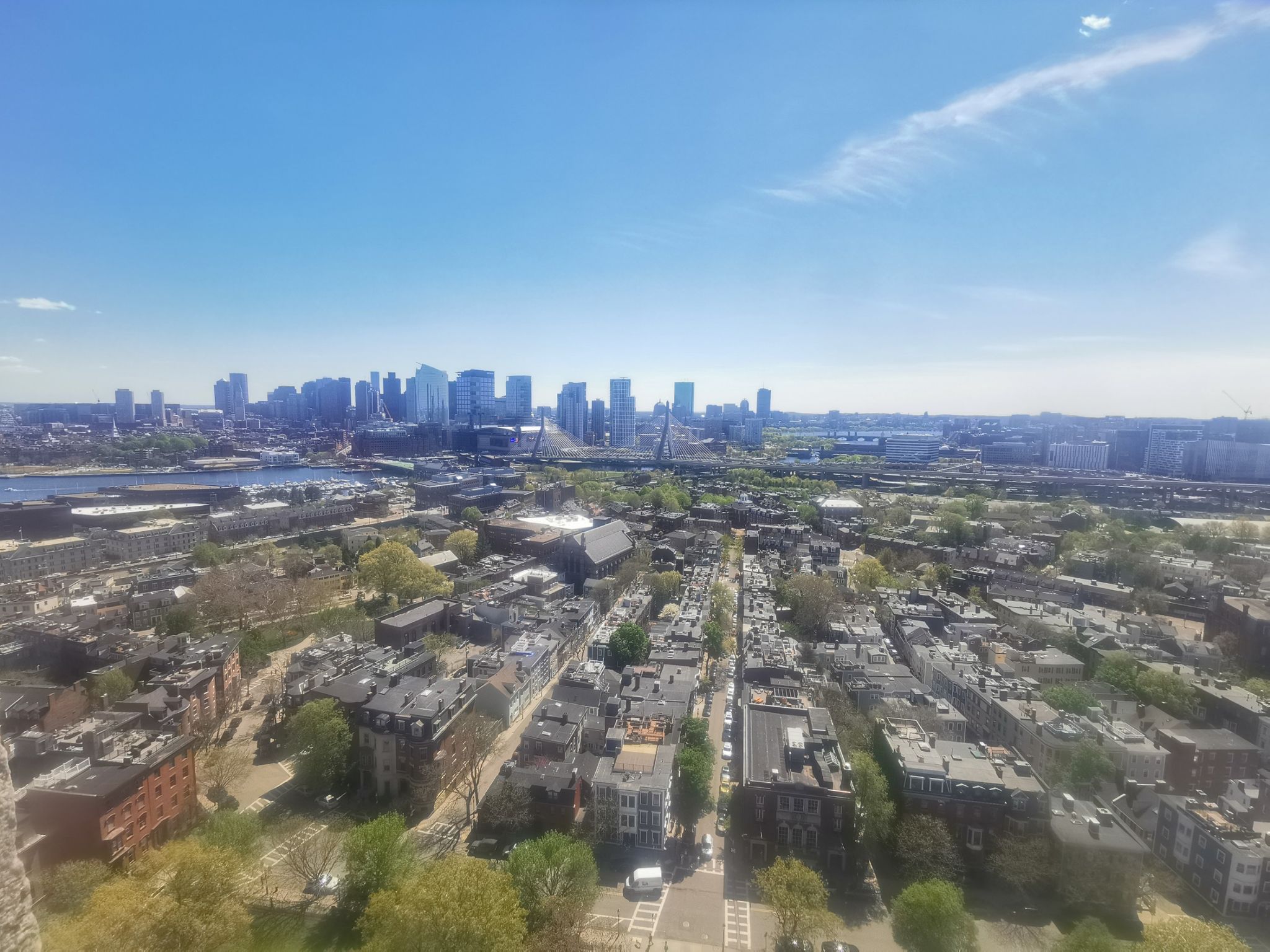Aerial view of a sprawling city with distant skyscrapers under a clear blue sky. - Freedom Trail