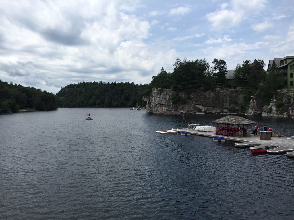 Overcast view of a lake, dock with people, and cliffs with a building. - Lemon Squeeze and Eagle Cliff