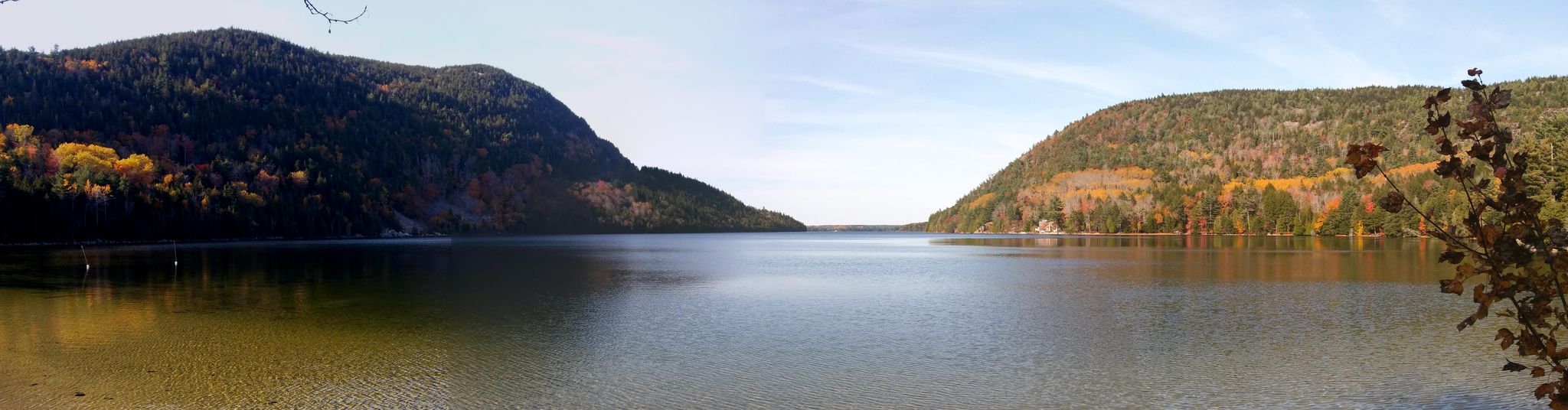 Panoramic view of a calm lake between two forested mountains under a clear sky. - Beech Mountain West Ridge Trail