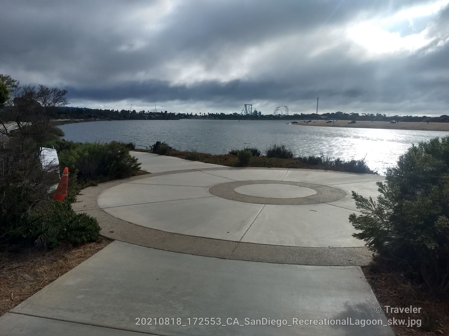 Paved circular area next to a lake under a cloudy sky. - Mission Bay Park – Rose Canyon Bike Route loop from Arnele Avenue
