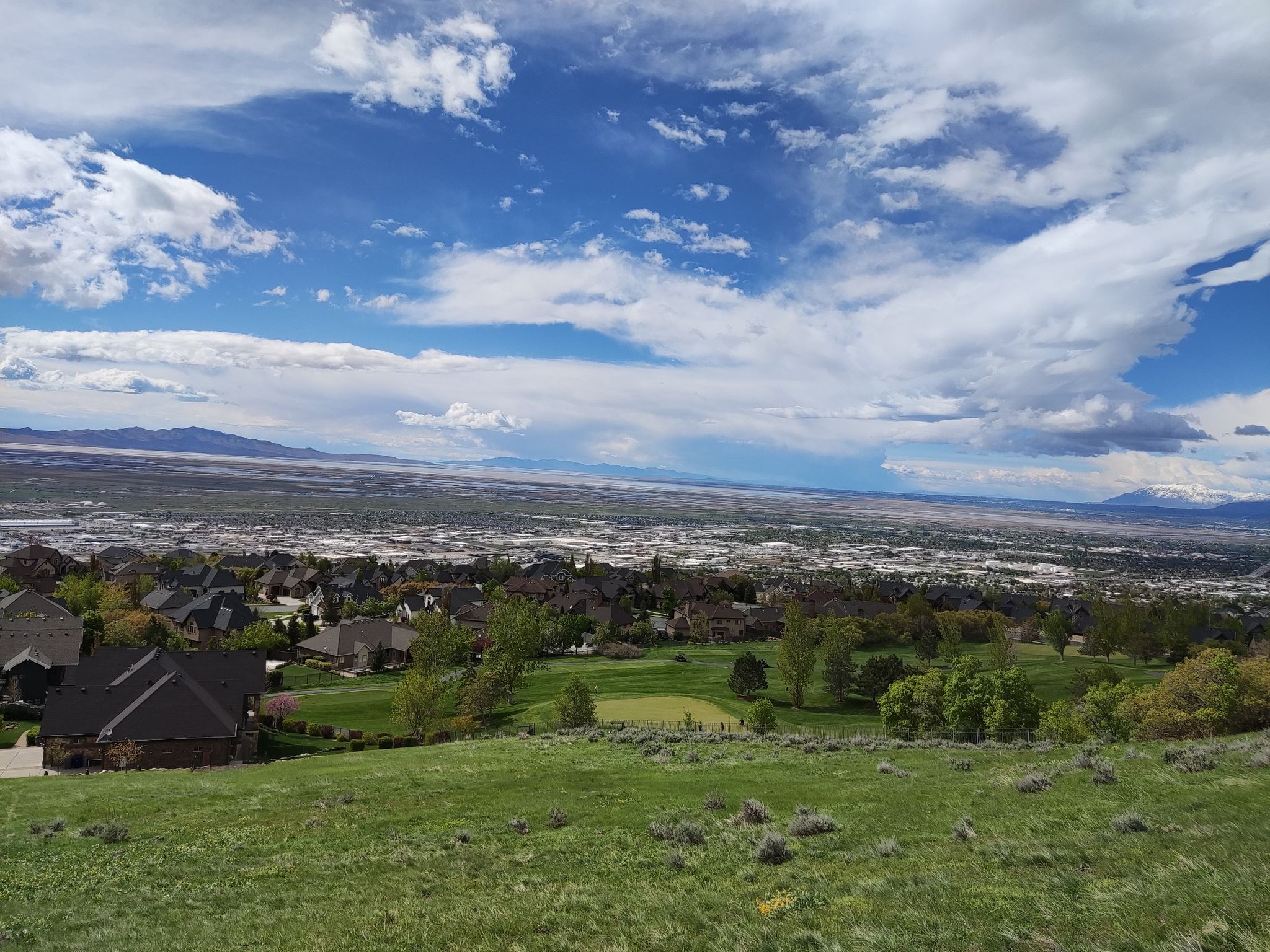 Expansive view of a town, golf course, and mountains under a bright, cloudy sky. - Dude Benchmark – Grandview Route loop from The Church of Jesus Christ of Latter-day Saints