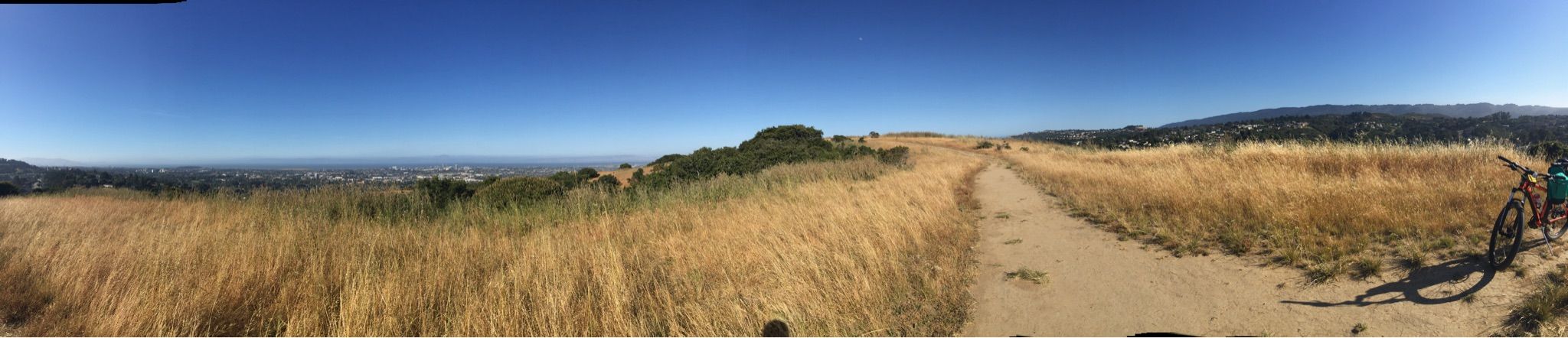 Wide dirt trail through golden dry grass fields with a bicycle. - Sugarloaf Mountain loop from Laurelwood Park
