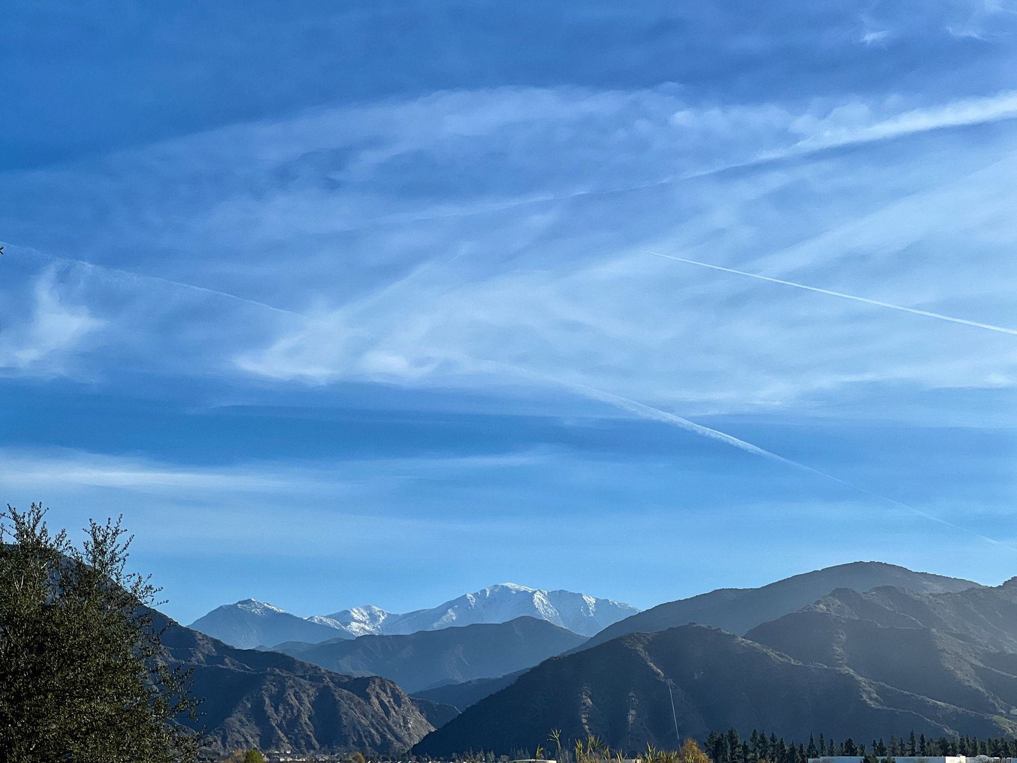 Distant snow-capped mountains under a bright blue sky with airplane contrails. - Duarte Bike Trail – Monrovia Historic Downtown loop from Sierra Madre Villa