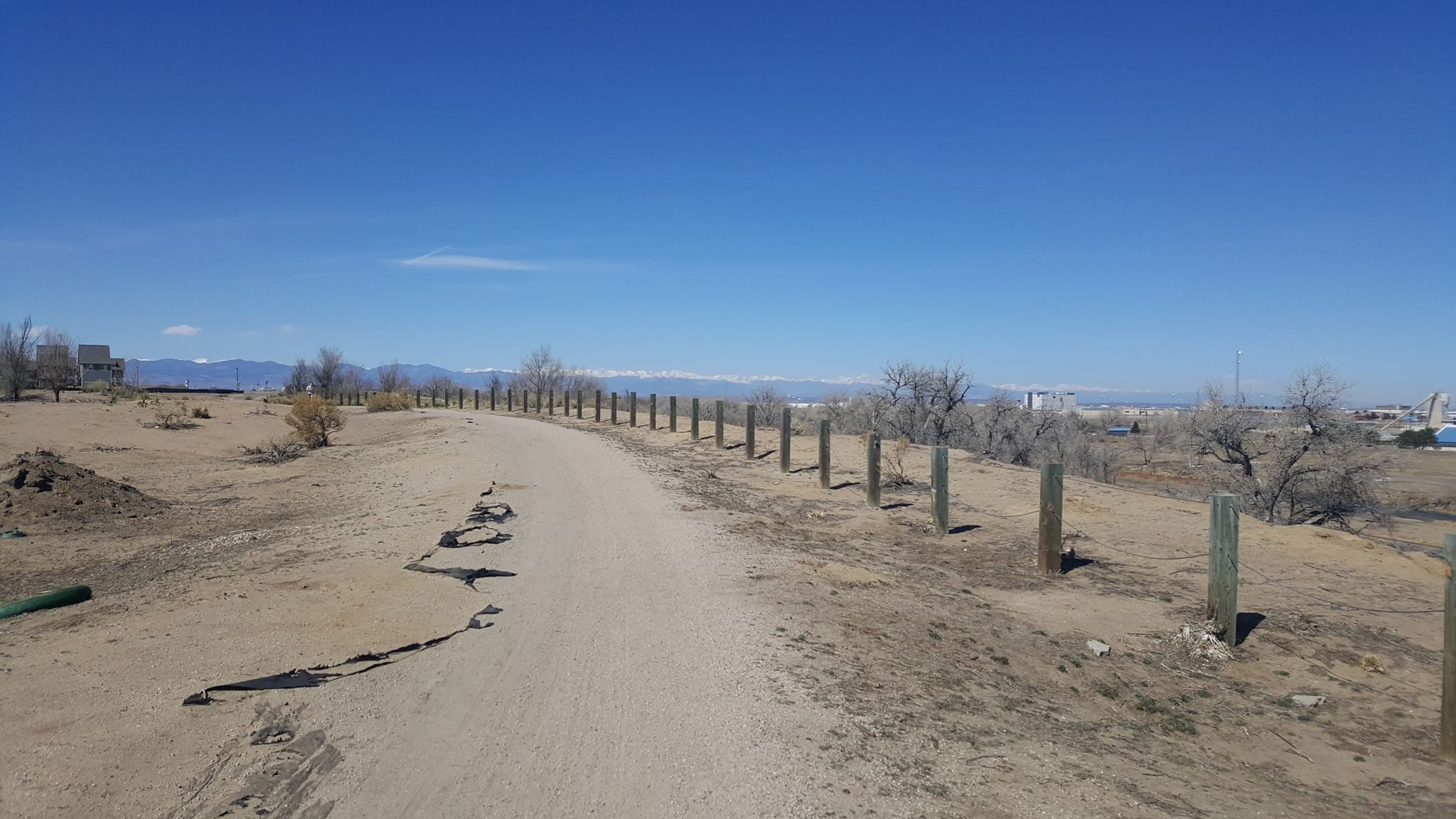 Sunny dirt path with wooden posts through dry, sparse landscape. - Colorado Front Range Trail