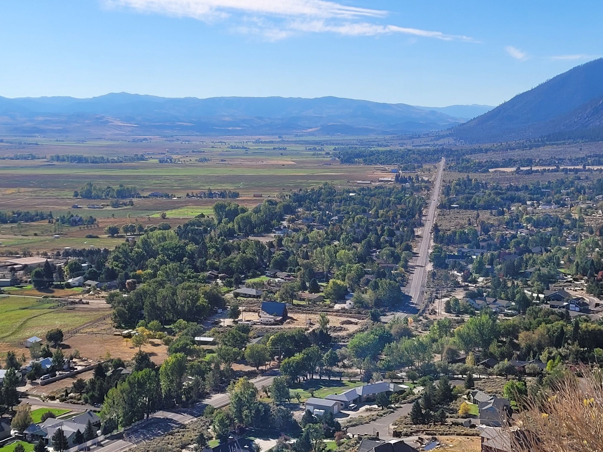 Aerial view of a green valley with a town, road, and distant mountains. - Rabe Meadows Preserve – South Lake Tahoe Beach loop from Stateline