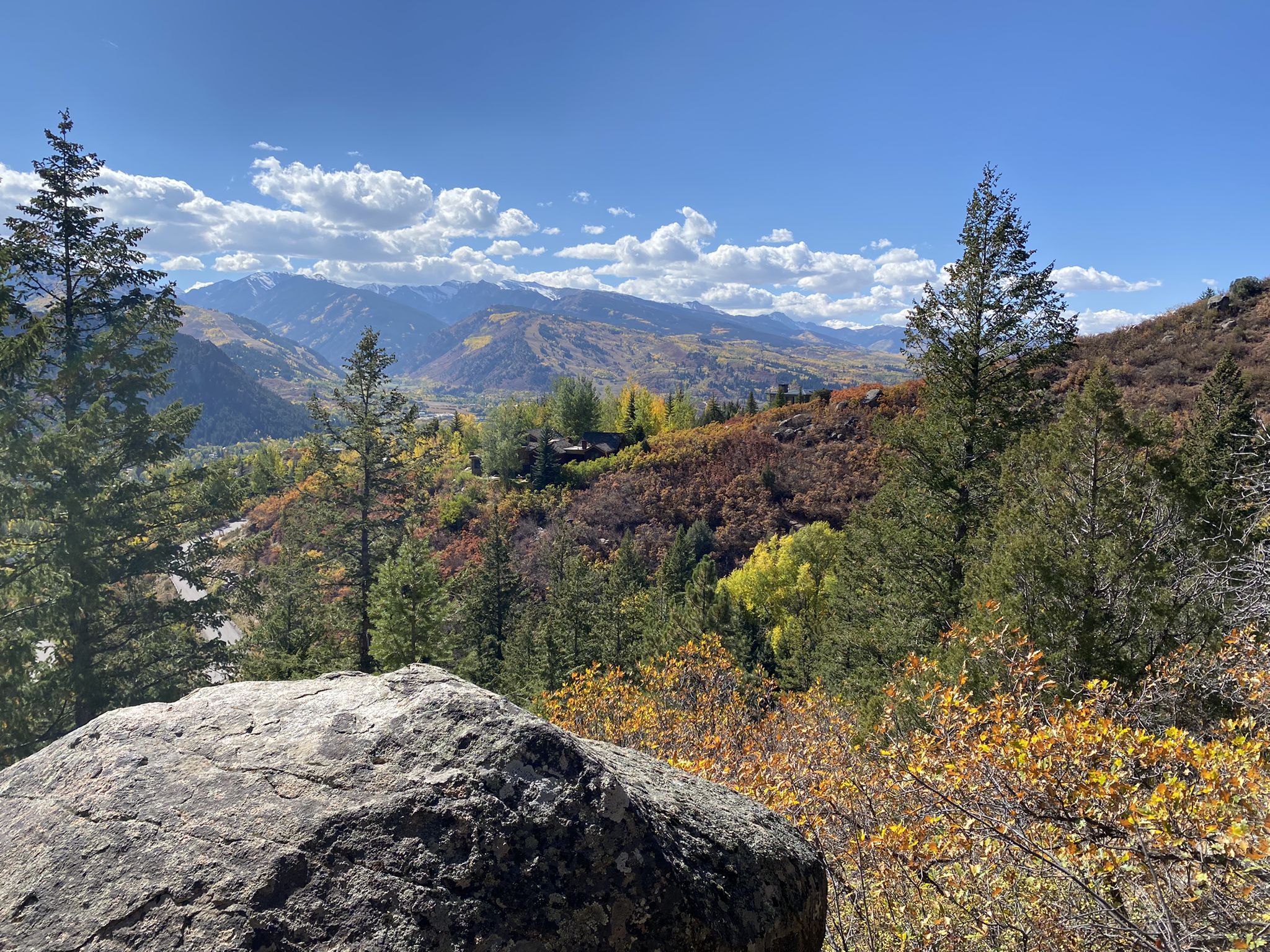 Sunny mountain landscape with vibrant autumn trees and a large foreground rock. - Hunter Creek and Red Mountain Loop