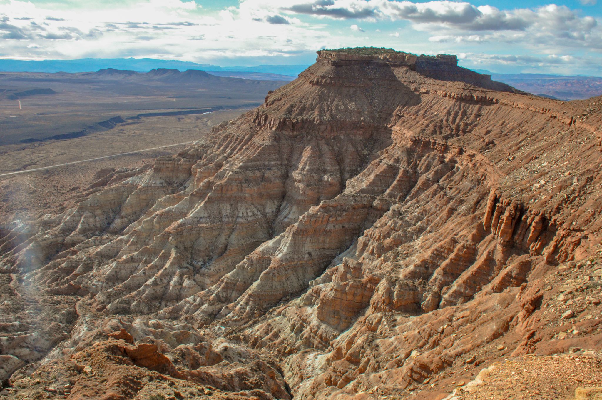Vast red rock canyon with steep, layered cliffs under a partly cloudy sky. - Gooseberry Mesa – MTB Trails in Hurricane, Utah