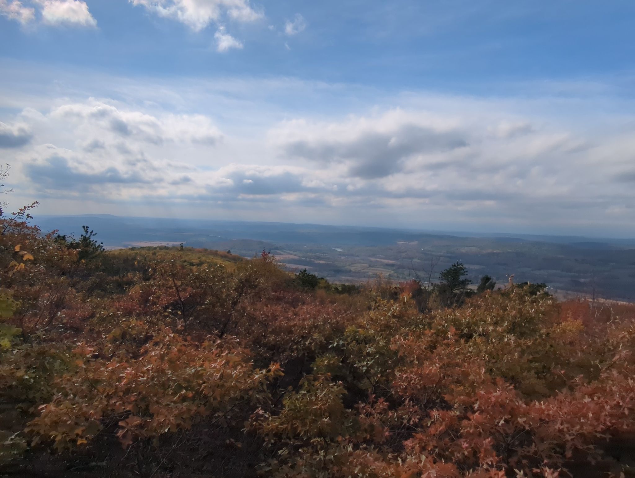 Overlook of autumn-colored hills and a distant valley under a cloudy sky. - Sunset Rock Trail