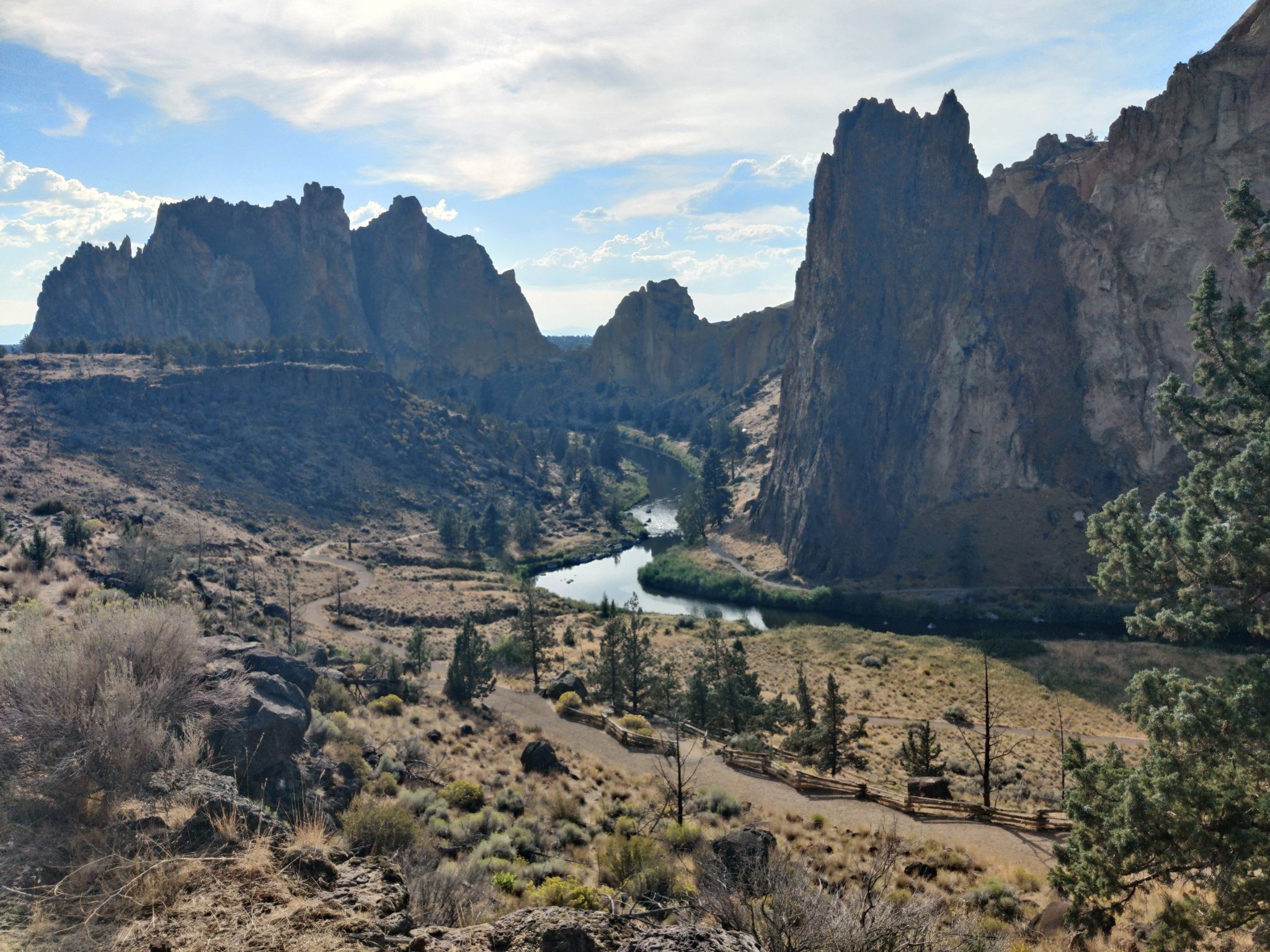 River in a canyon with large rock formations and dry vegetation under a partly cloudy sky. - Canyon Trail and Rim Rock Trail Loop