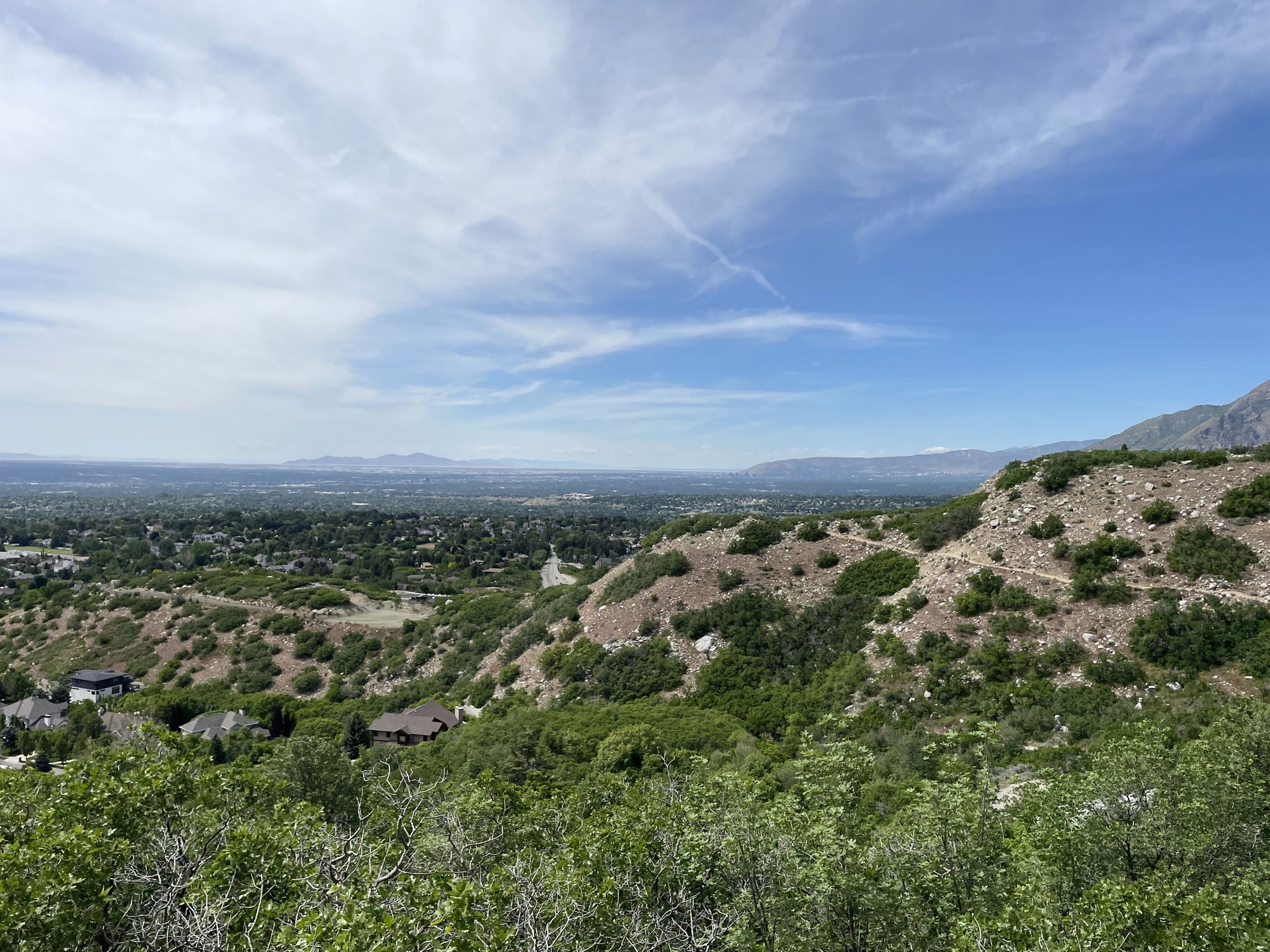 Panoramic view of a green valley with a city under a bright sky. - Bells Canyon Trail to Lower Falls