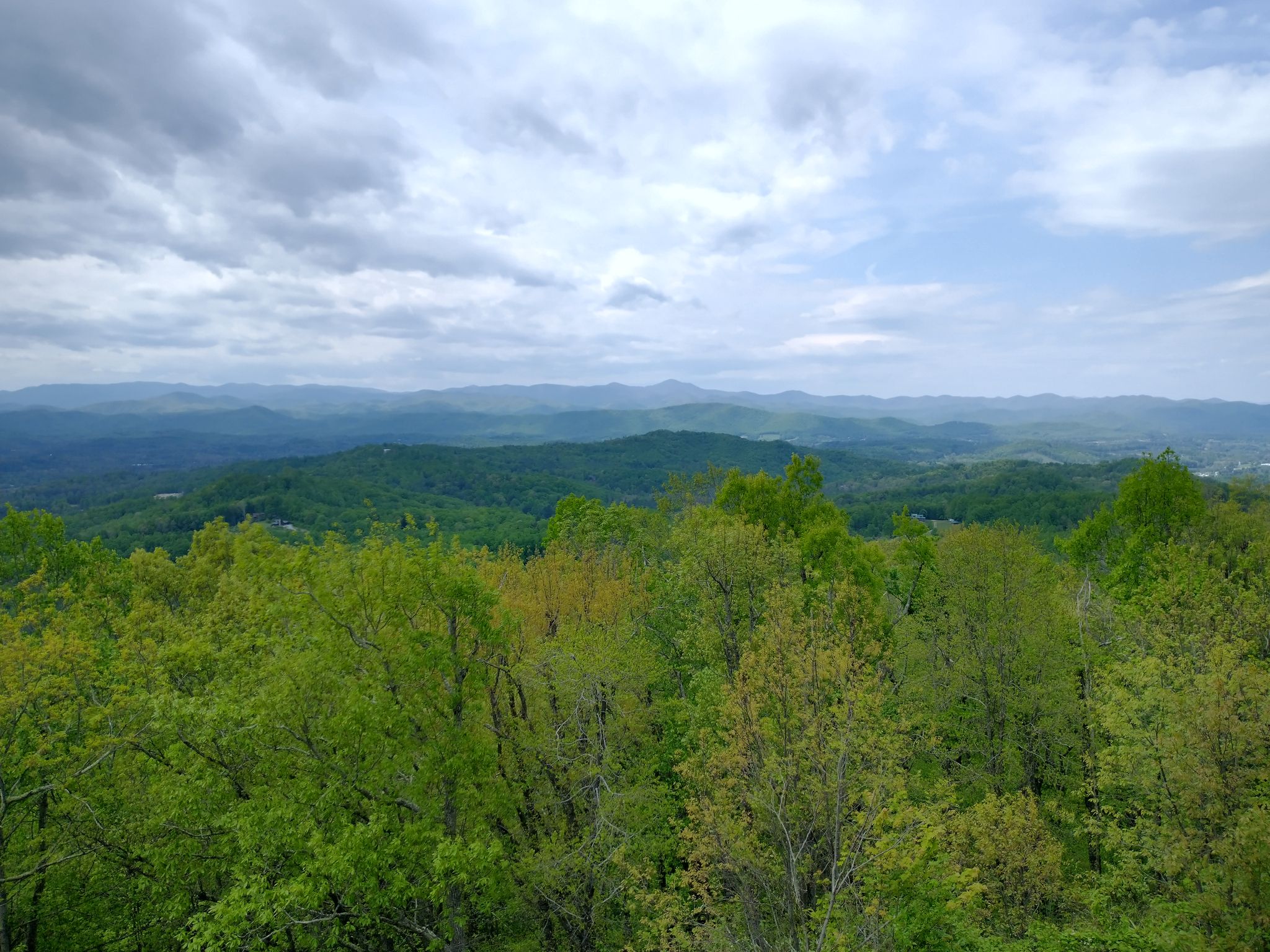 Expansive view of lush green mountains under a cloudy sky. - Jump Off Rock Blue Trail