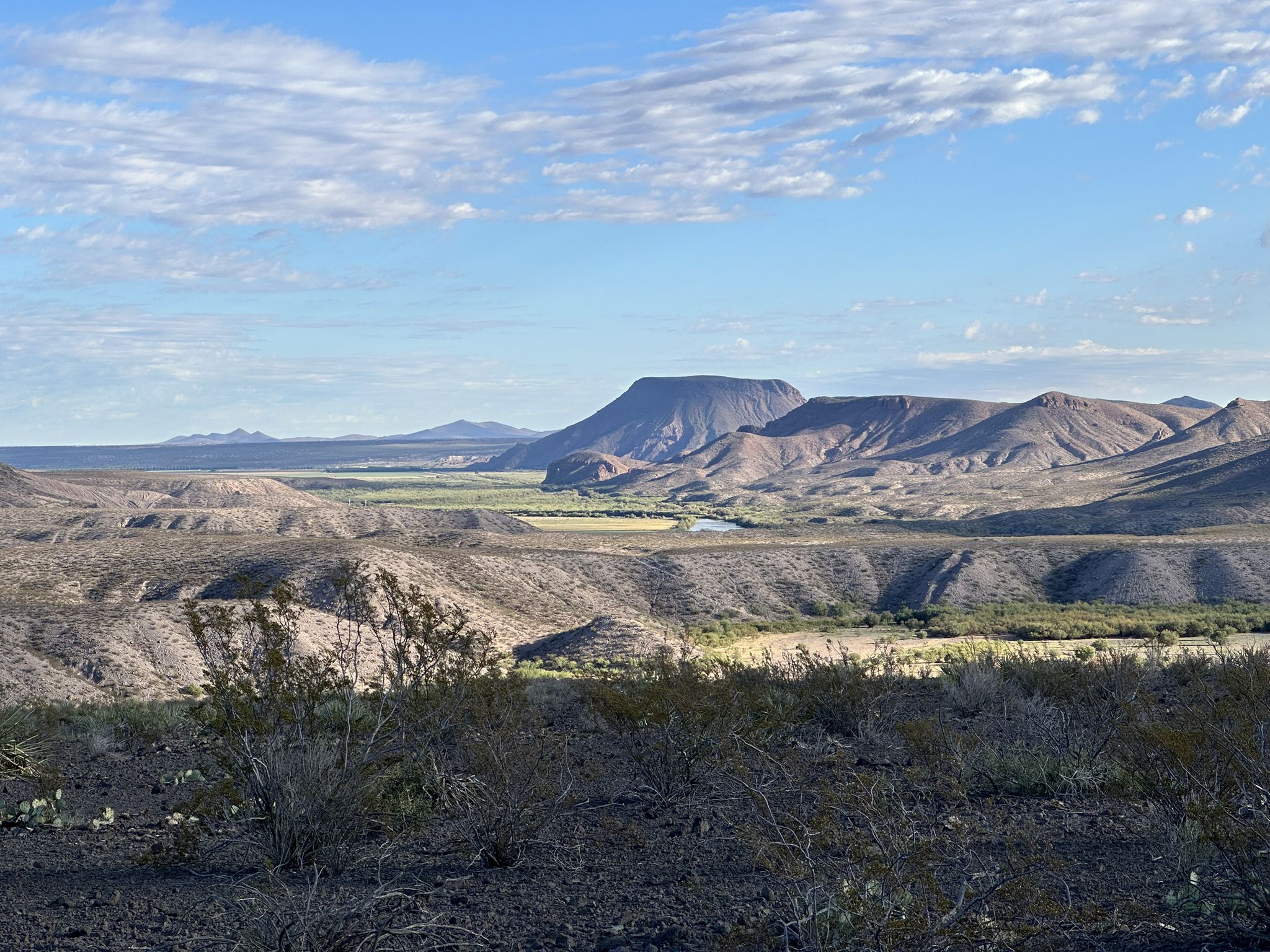 Expansive desert landscape with mountains, a green valley, and a river. - Leasburg Slot Canyon Trail