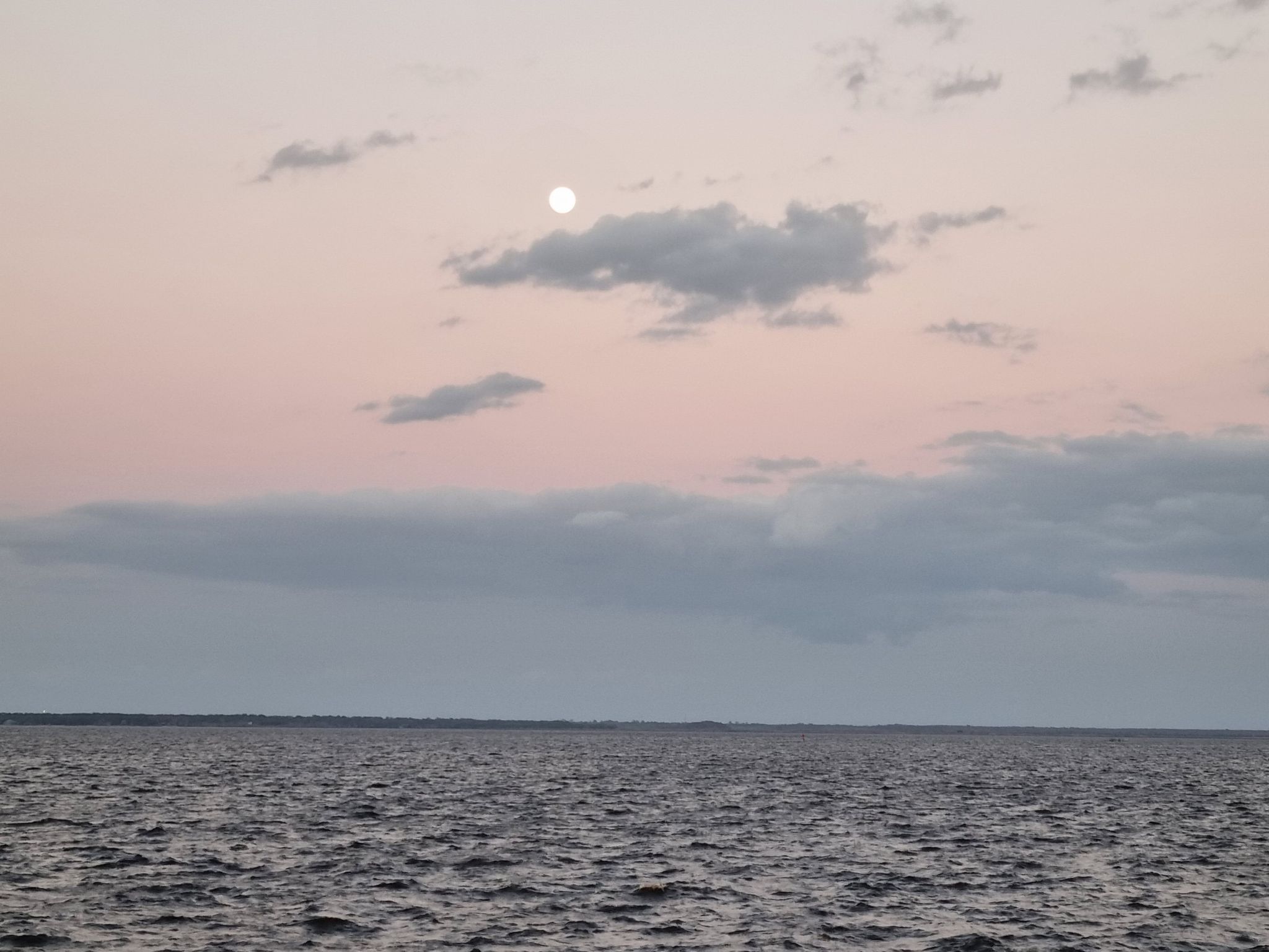 Full moon visible above a vast expanse of water at dusk. - Sanford Riverwalk Trail