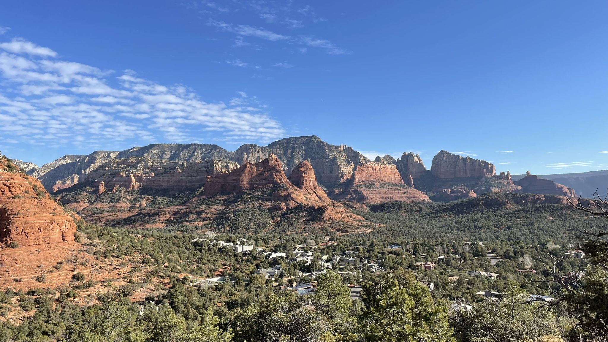 Panoramic view of red rock mountains, green trees, and a distant town. - Sugarloaf Summit loop from Rodeo & Shelby (Safeway)