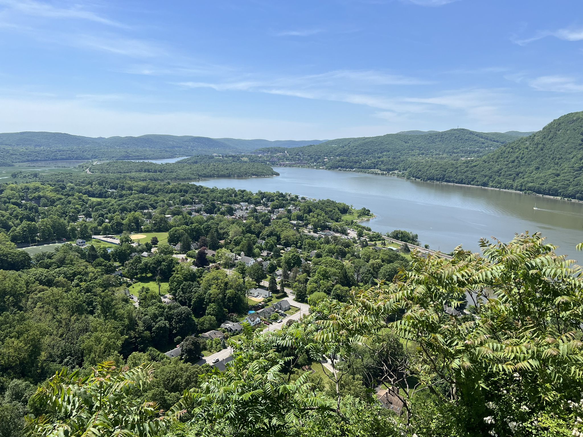 Overlook of a town by a river, surrounded by lush green forests on a sunny day. - Nelsonville Trail – Railway Station Cold Spring loop from Cold Spring