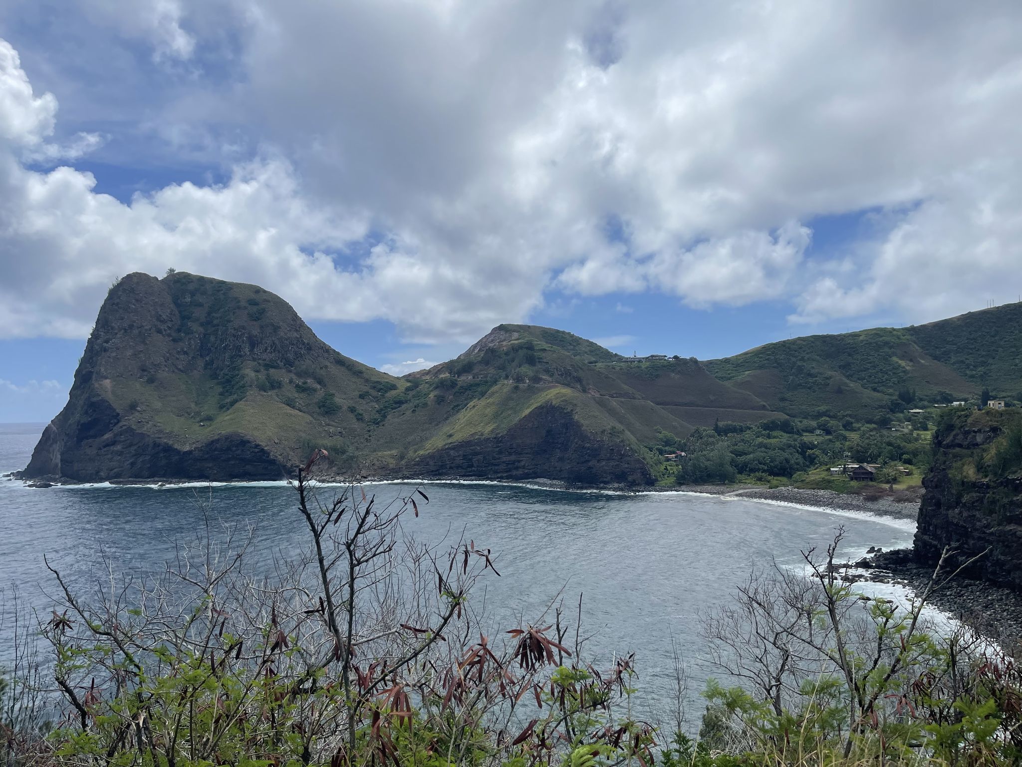 Bay with calm water, surrounded by lush green mountains under a cloudy sky. - Road to Lahaina – Honolua Bay loop from Kihei