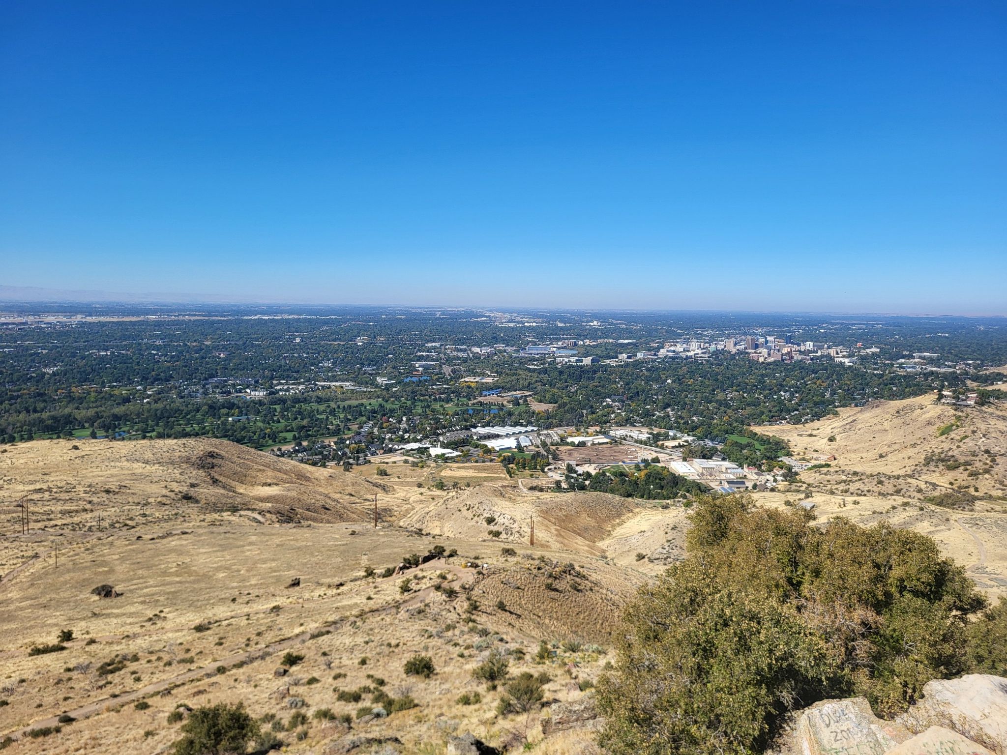 Expansive view of a distant city from dry, rocky hills on a clear day. - Table Rock Quarry Loop