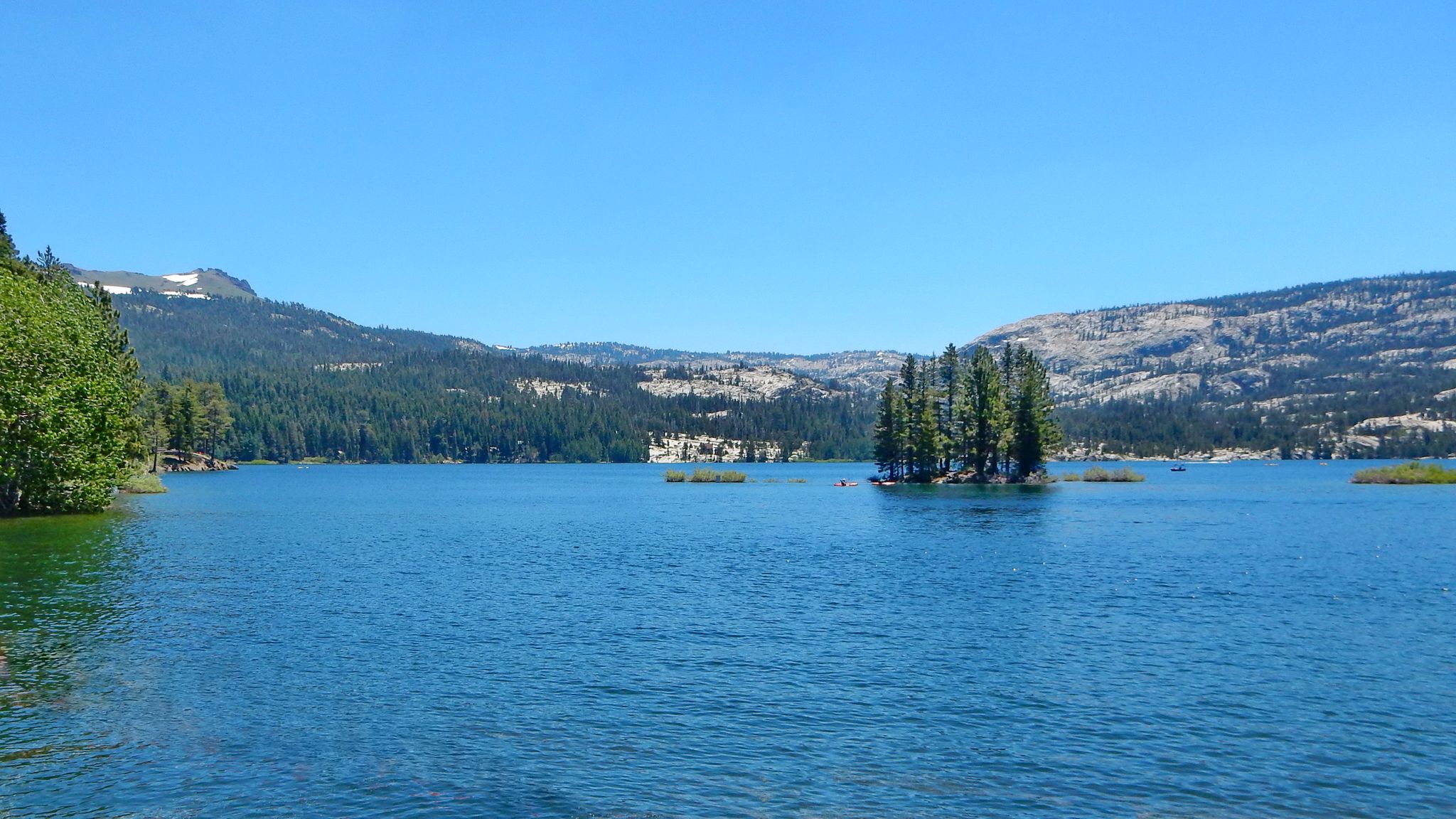 A clear blue lake with small forested islands under a bright, sunny sky. - Silver Lake via CA 88