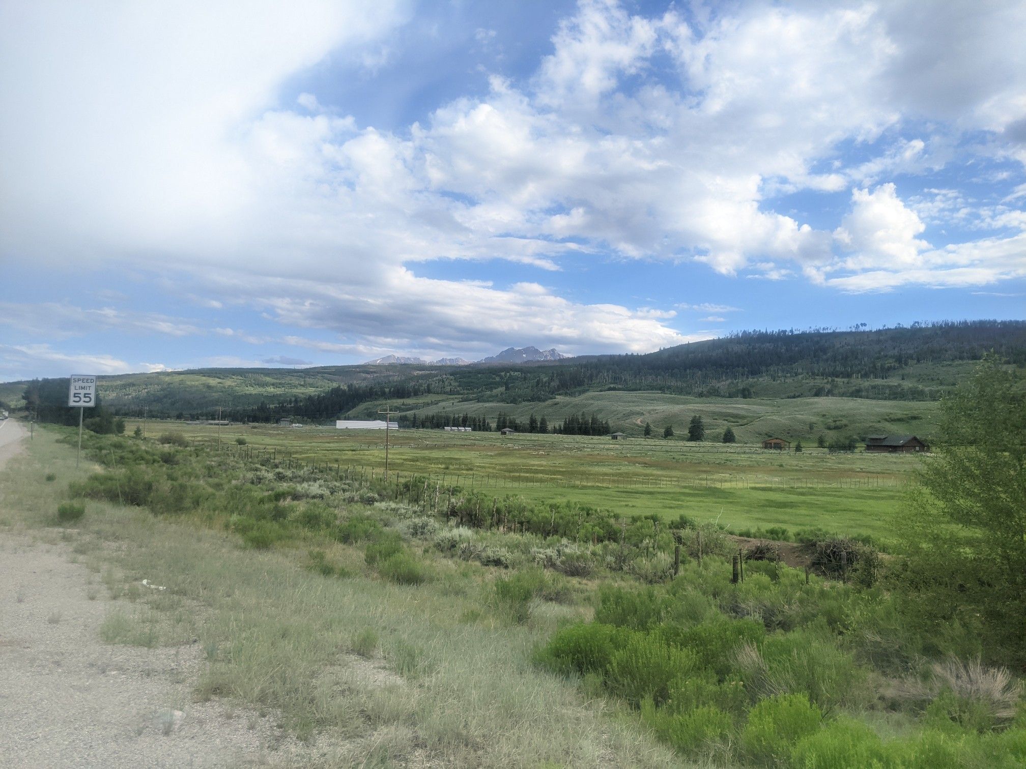 Vast green field with distant mountains under a partly cloudy sky. - Ute Pass from Silverthorne, Colorado