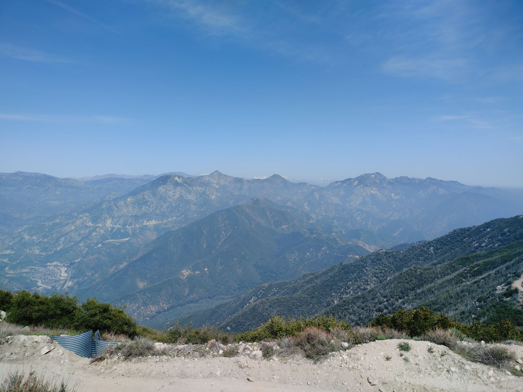 Distant mountain ranges and hazy horizon under a bright blue sky. - Mount Lukens via Earl Canyon Trail