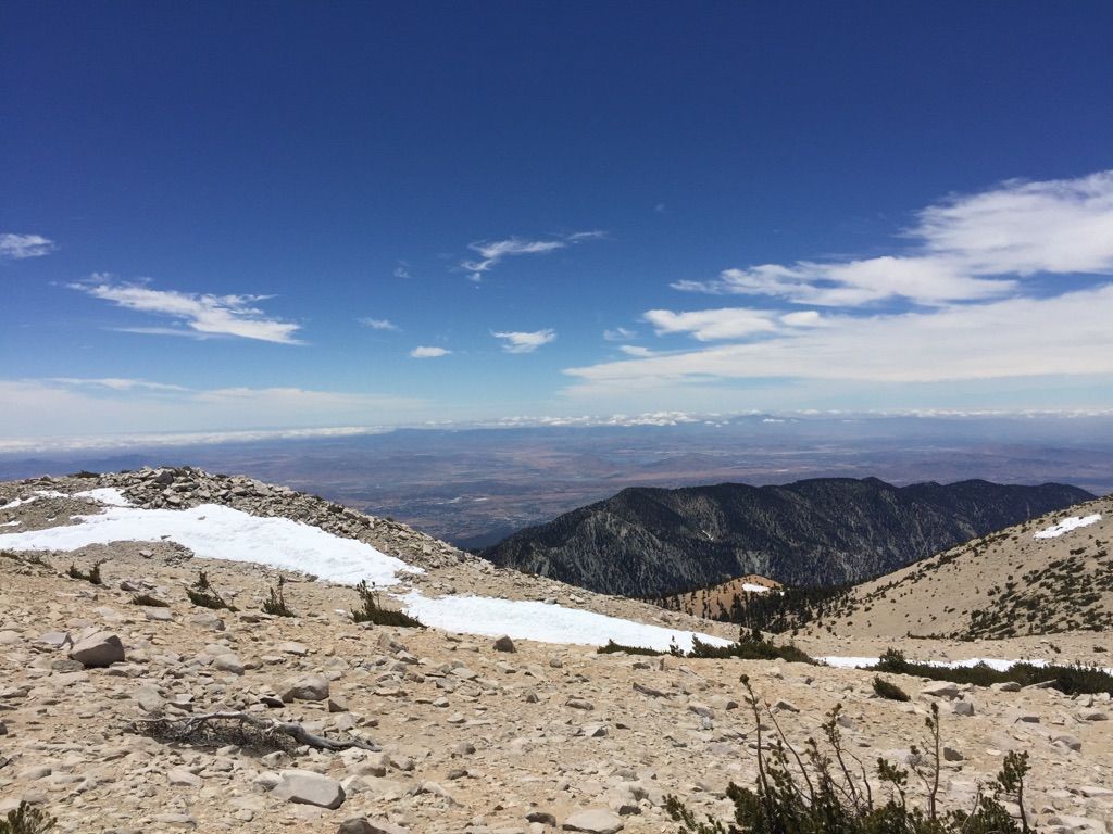 Rocky mountain terrain with snow patches and distant mountains, clear day. - San Gorgonio Mountain via Fish Creek Trail