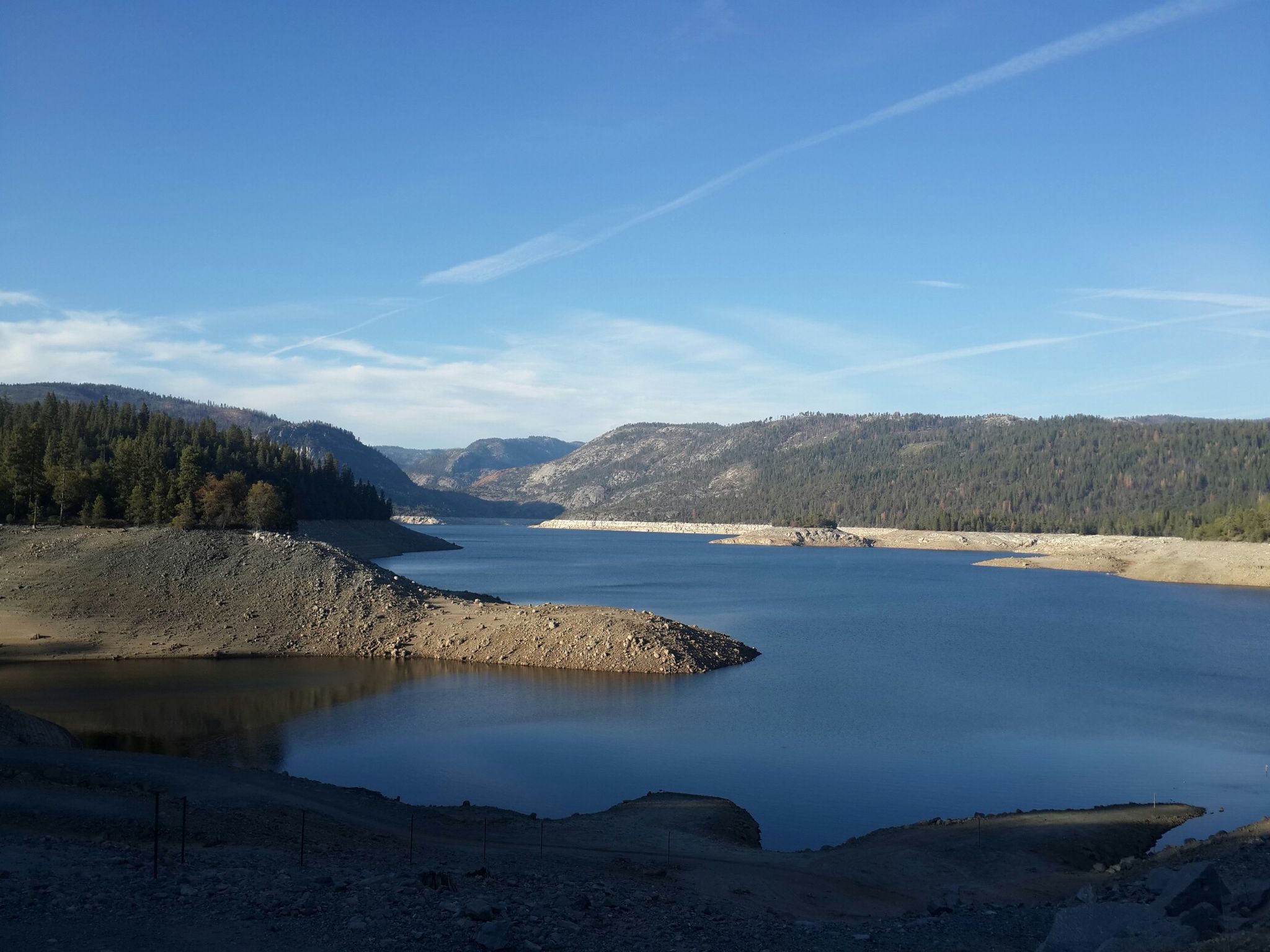 Expansive lake surrounded by forested mountains under a clear blue sky. - Lake Eleanor and Cherry Lake