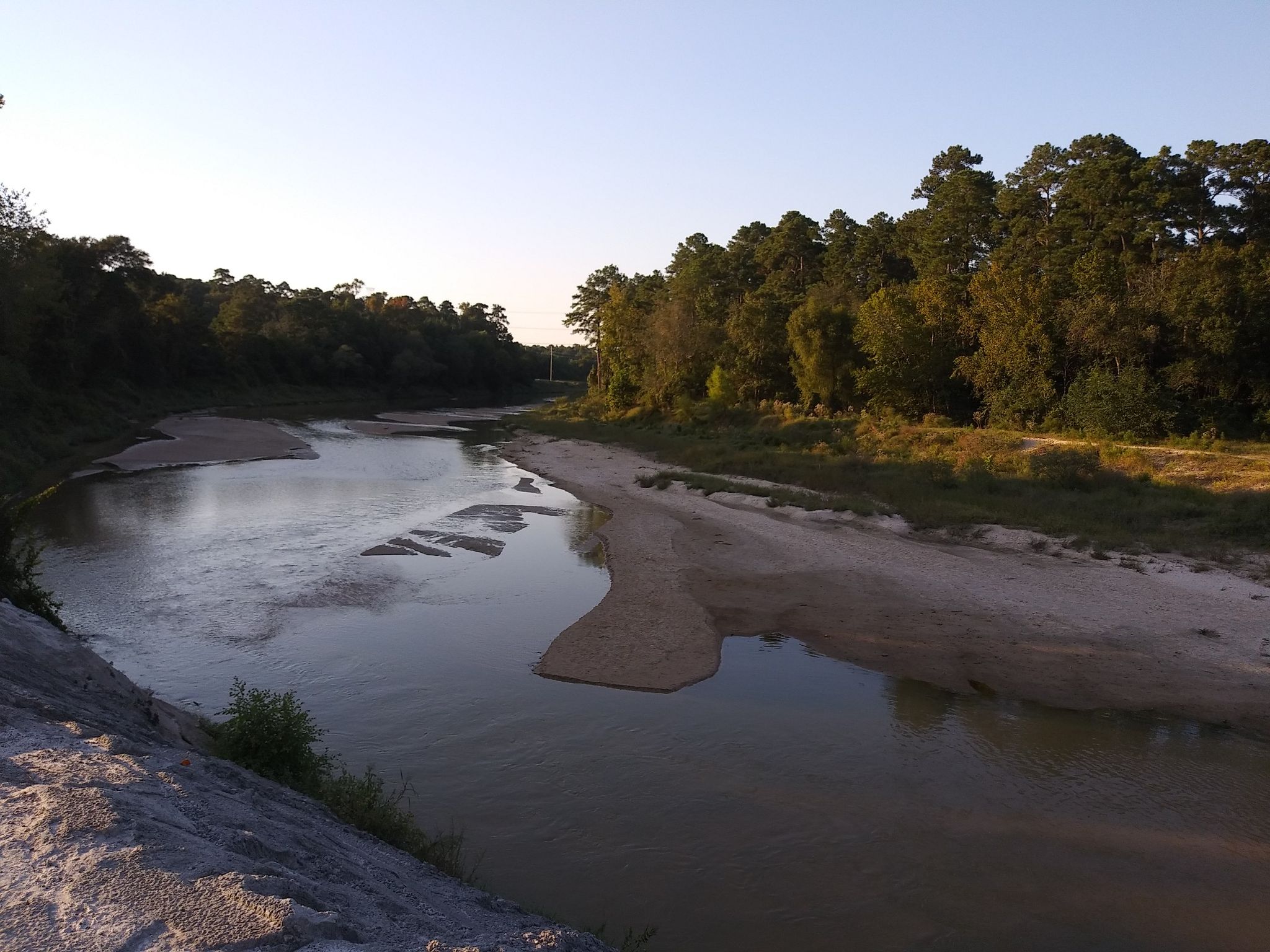 A wide river with sandy banks and forested shores at sunset. - Spring Creek loop from Science Parking