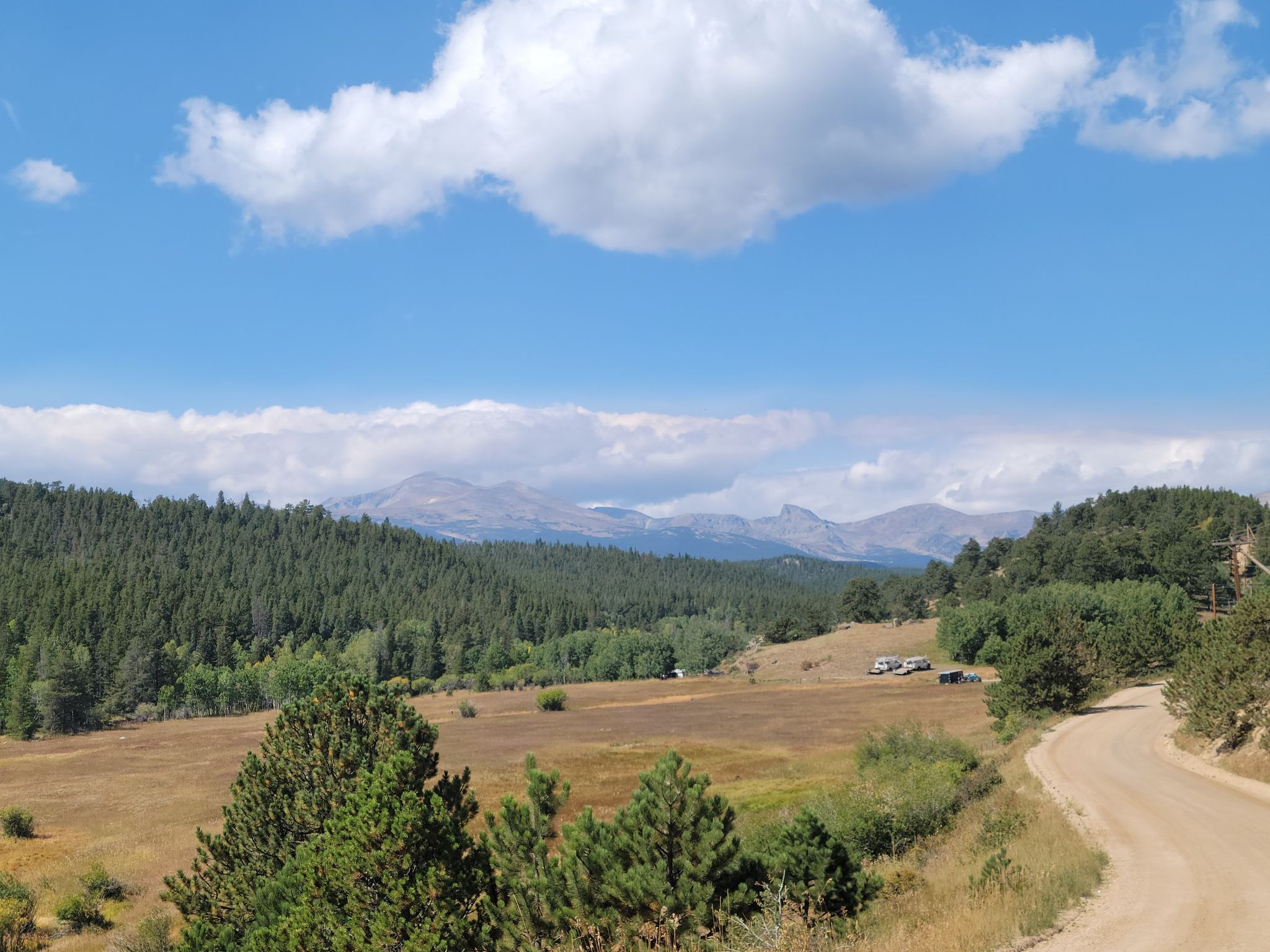 Distant mountains, forested hills, and an open field under a cloudy sky. - Jamestown Mercantile Café – Ward General Store loop from Bar-K Ranch