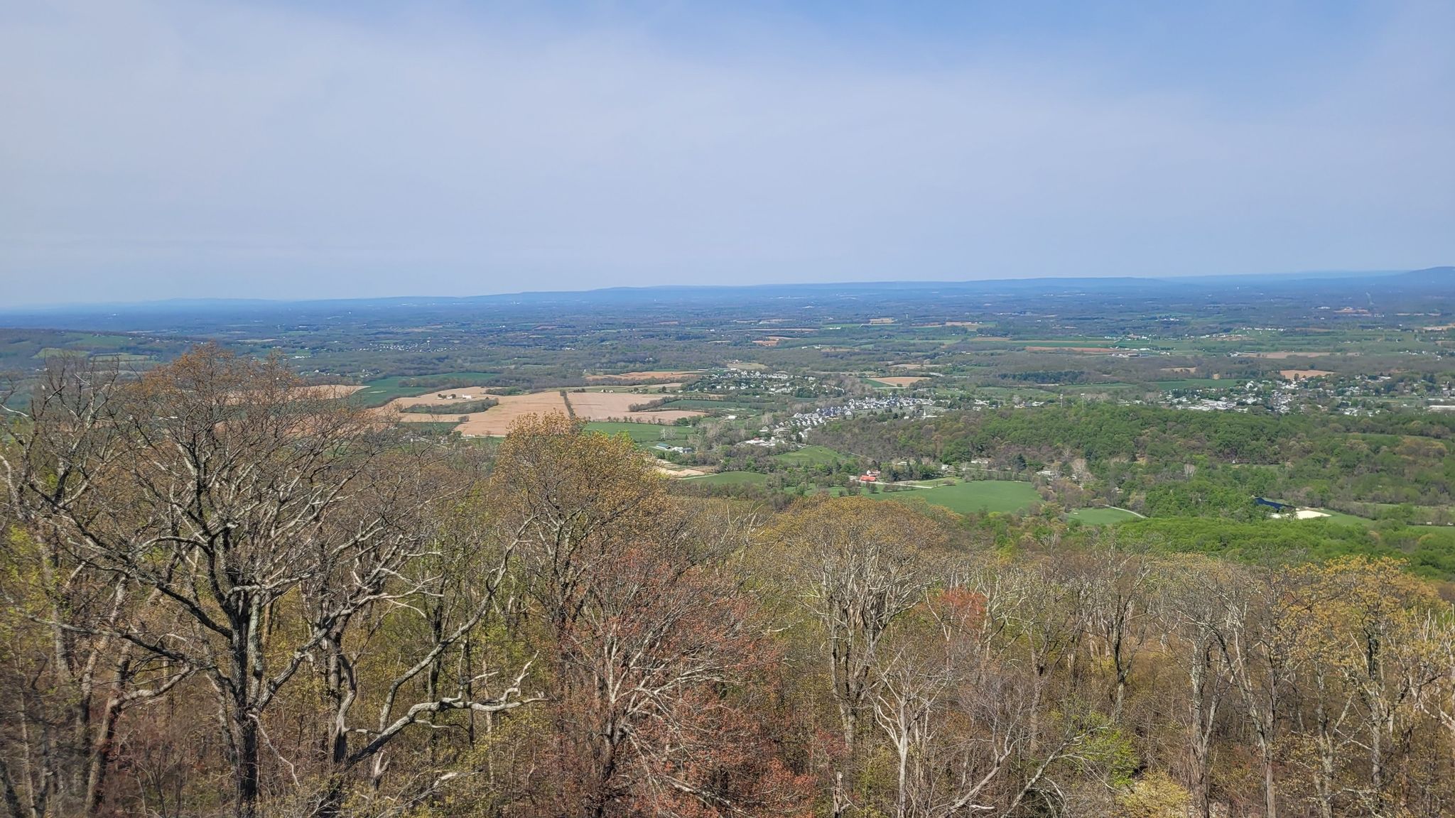Panoramic view of a vast valley with forests and fields under a clear sky. - Appalachian Trail: Greenbrier to Washington Monument