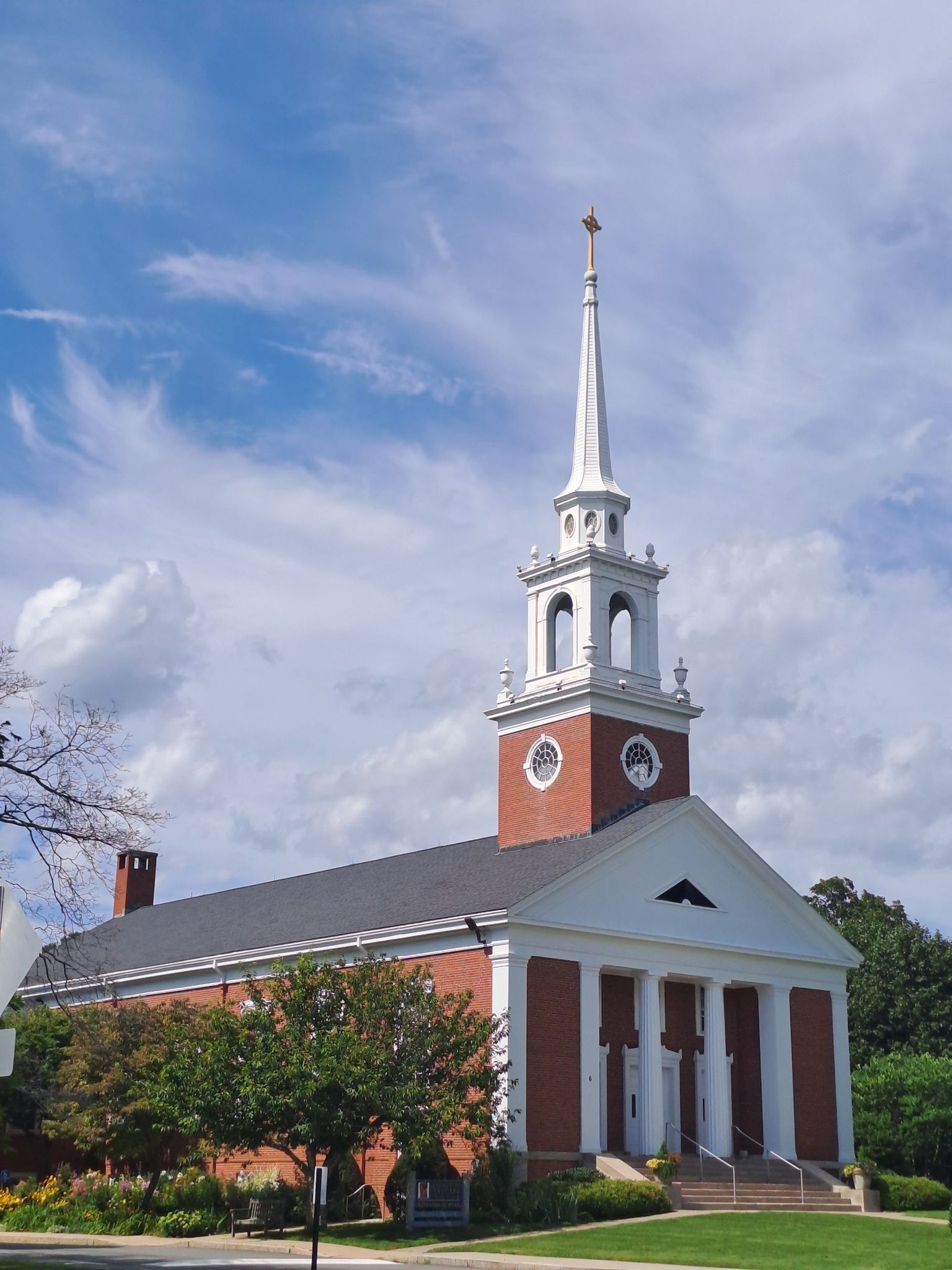 Red brick church with a tall white steeple under a blue sky. - Harold Parker State Forest loop
