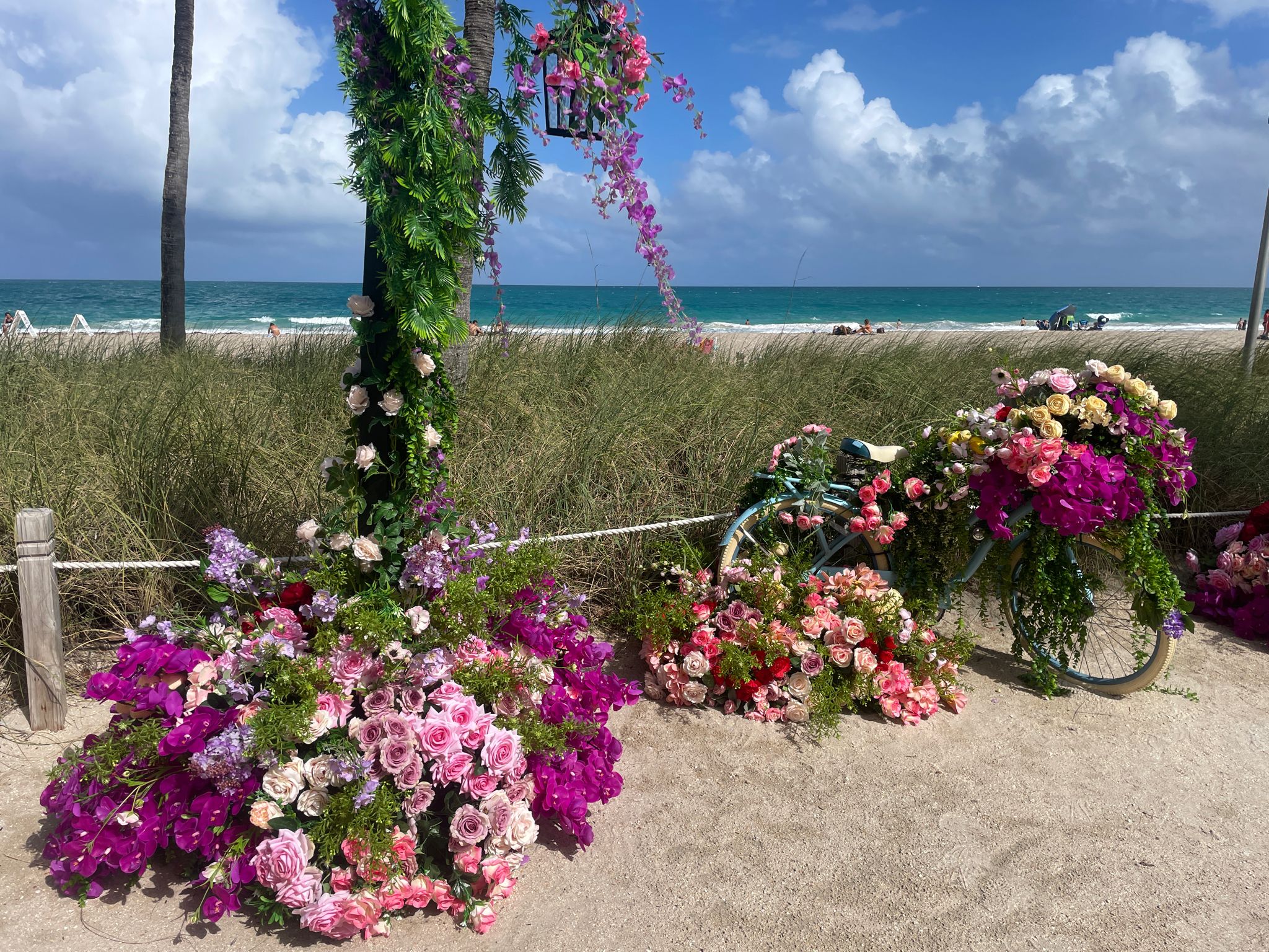 Bicycle and arch decorated with many colorful flowers on a path. - Running loop from Bal Harbour Village
