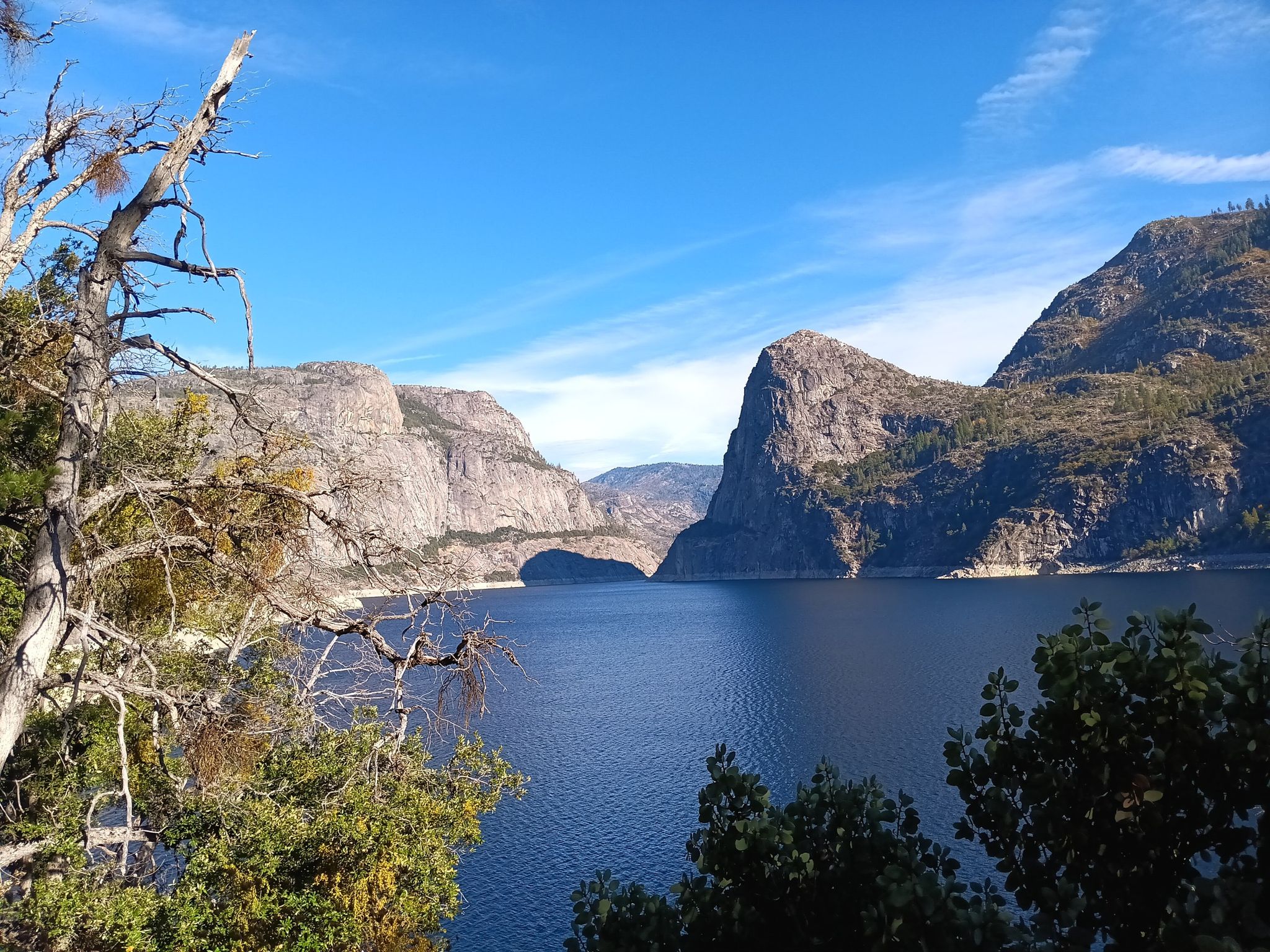 Deep blue lake framed by large, rocky mountains and a clear sky. - O'Shaughnessy Dam View – Hetch Hetchy Reservoir loop from O'Shaughnessy Dam
