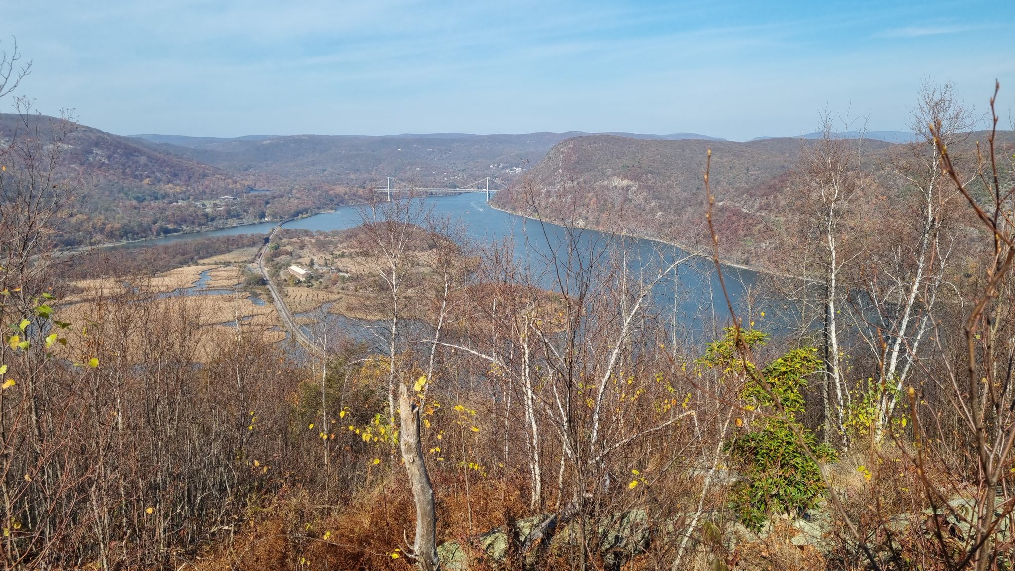 Panoramic view of a wide river, distant bridge, and forested hills under clear sky. - Ramapo-Dunderberg and Timp-Torne Trail Loop