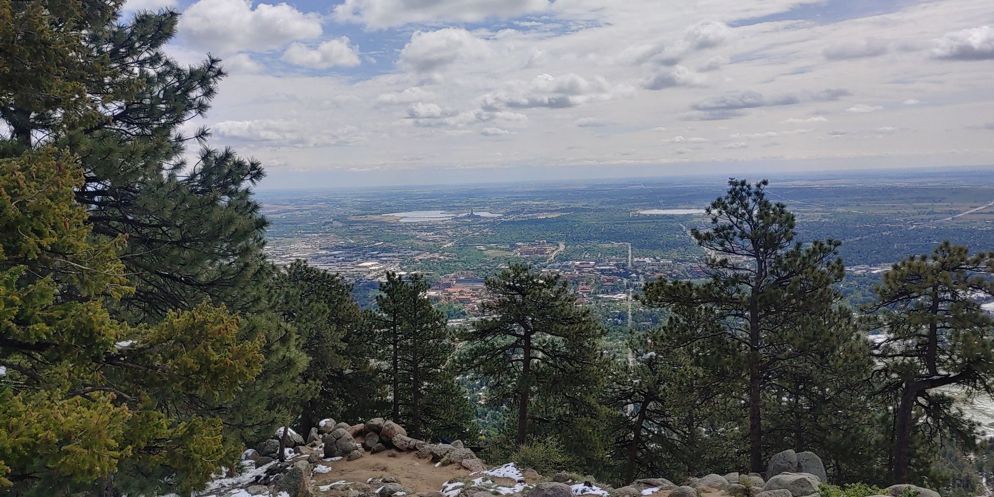 Overcast view from a mountain, pine trees framing a distant city and plains. - Range View, Ute, May's Point, and Boy Scout Trail Loop