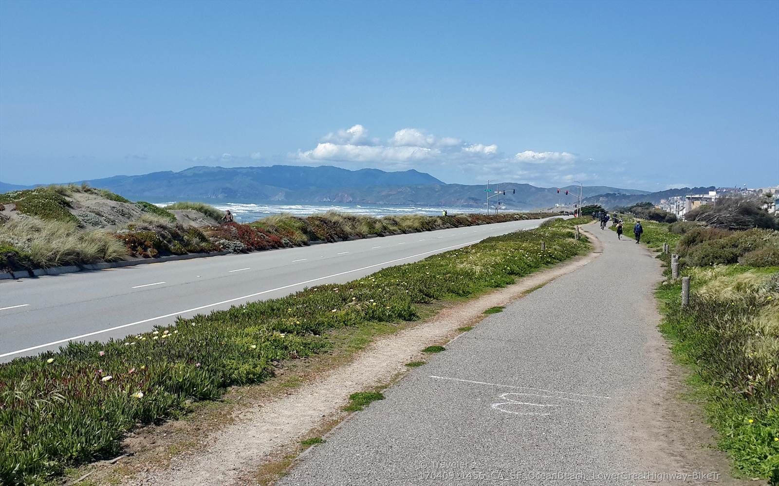 Paved road and path alongside sand dunes, with distant mountains. - Murphy Windmill – Golden Gate Park loop from Judah Street & 9th Avenue