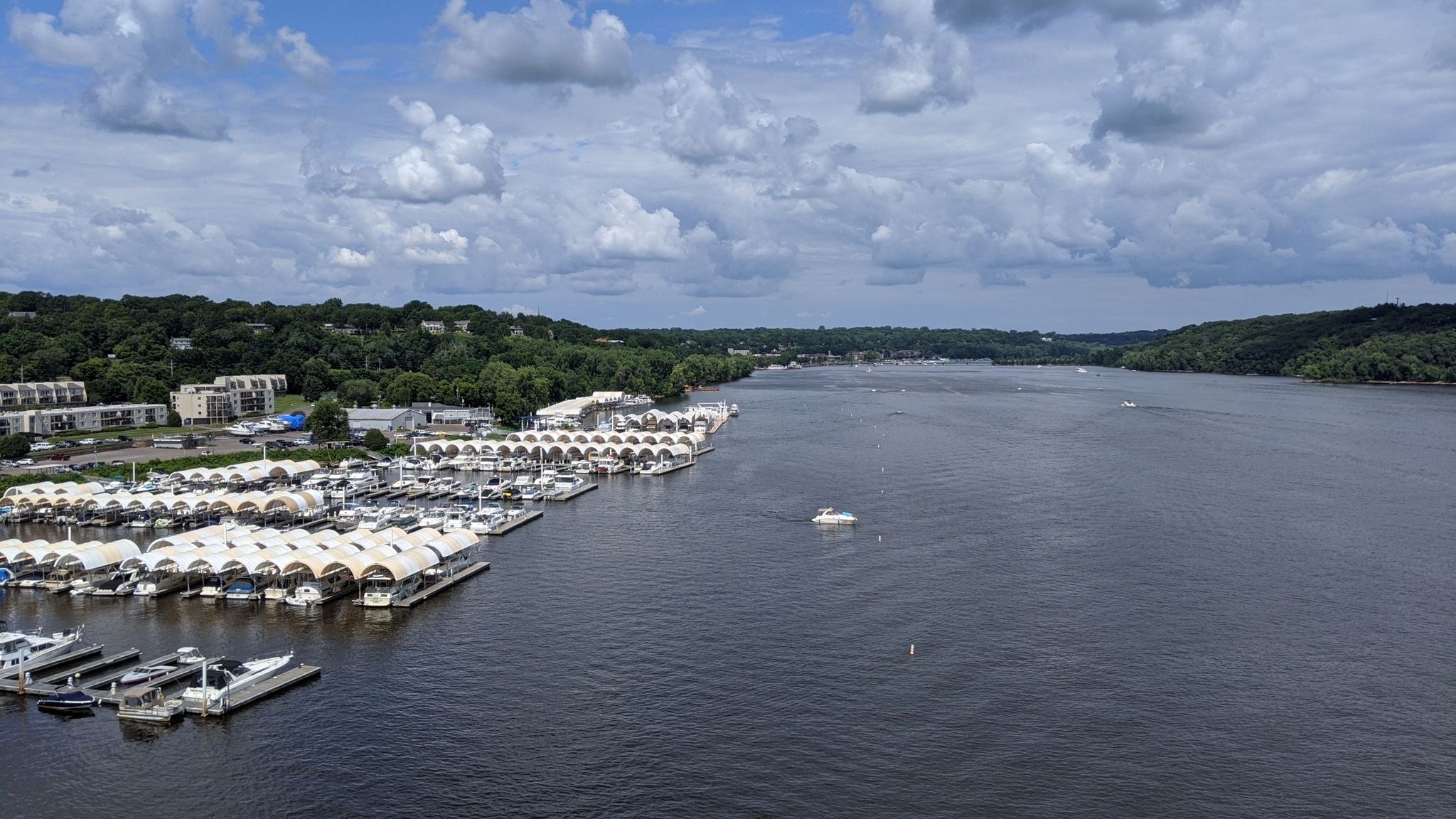 Marina with many boats along a wide river, green hills, cloudy. - St. Croix Crossing Bridge – Stillwater Lift Bridge loop from Stillwater