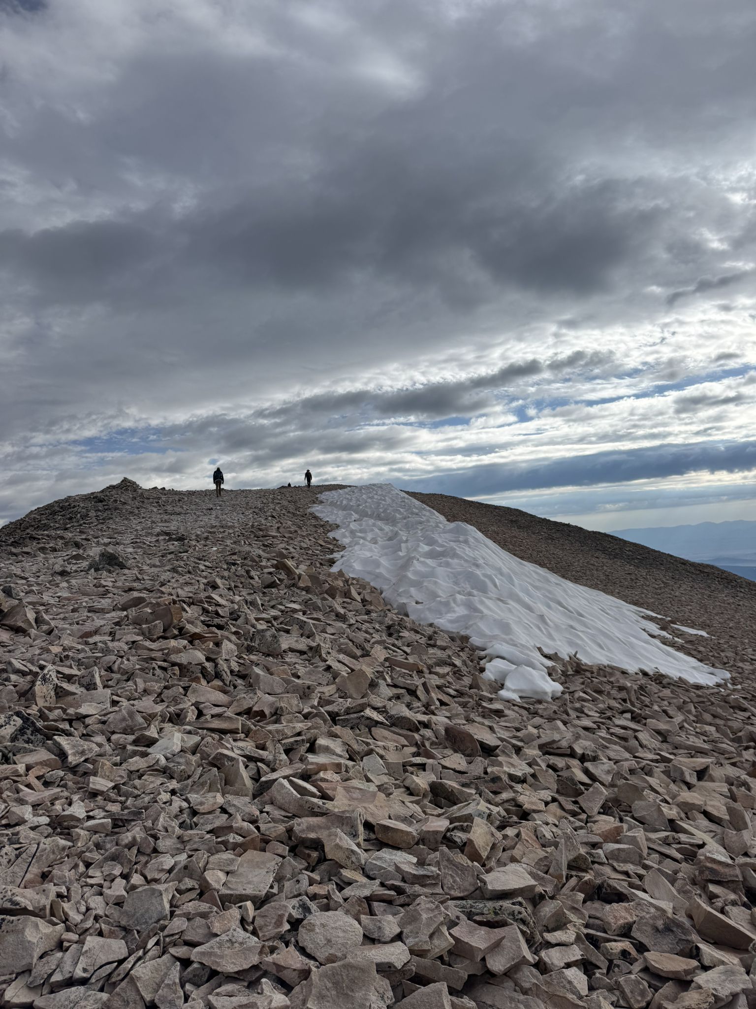 Two hikers on a rocky mountain ridge with snow under cloudy skies. - Mount Sherman - Southwest Ridge from Fourmile Creek