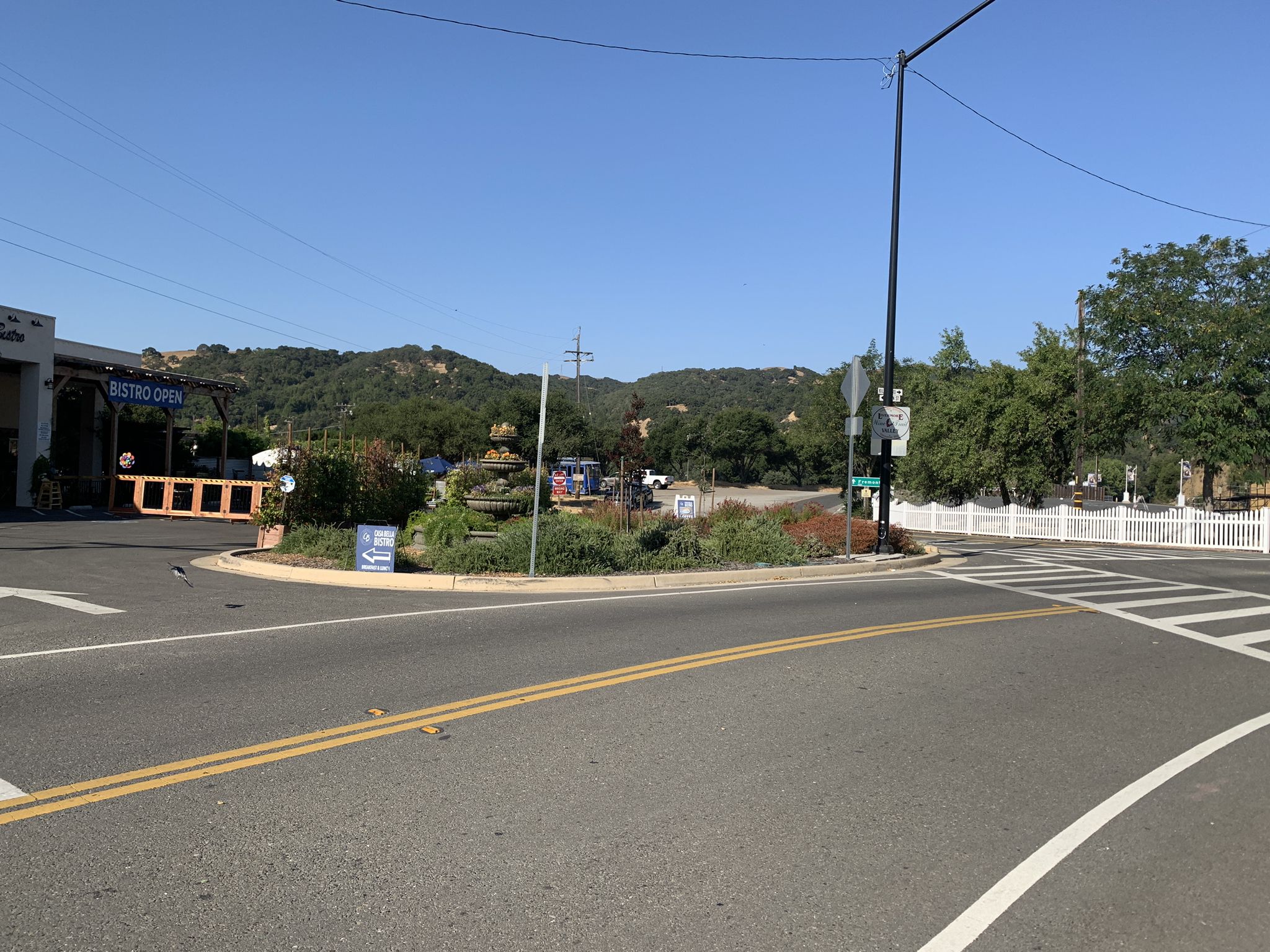 A road intersection with a landscaped roundabout on a sunny day. - Sunol Depot – Pleasanton Ridge Regional Park loop from East Stanley Boulevard & Murdell Lane