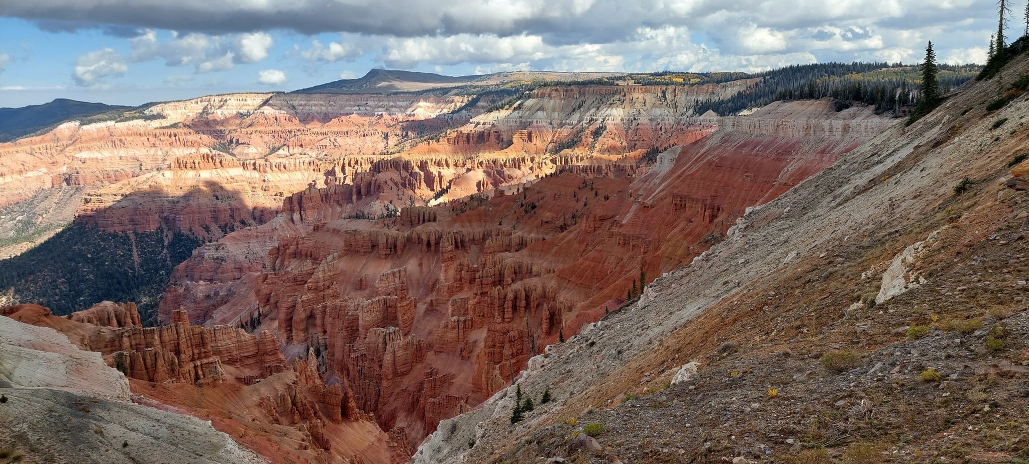 Deep red rock canyon with dramatic eroded slopes under a cloudy sky. - Cedar Breaks National Monument – Rampart Overlook loop from Point Supreme