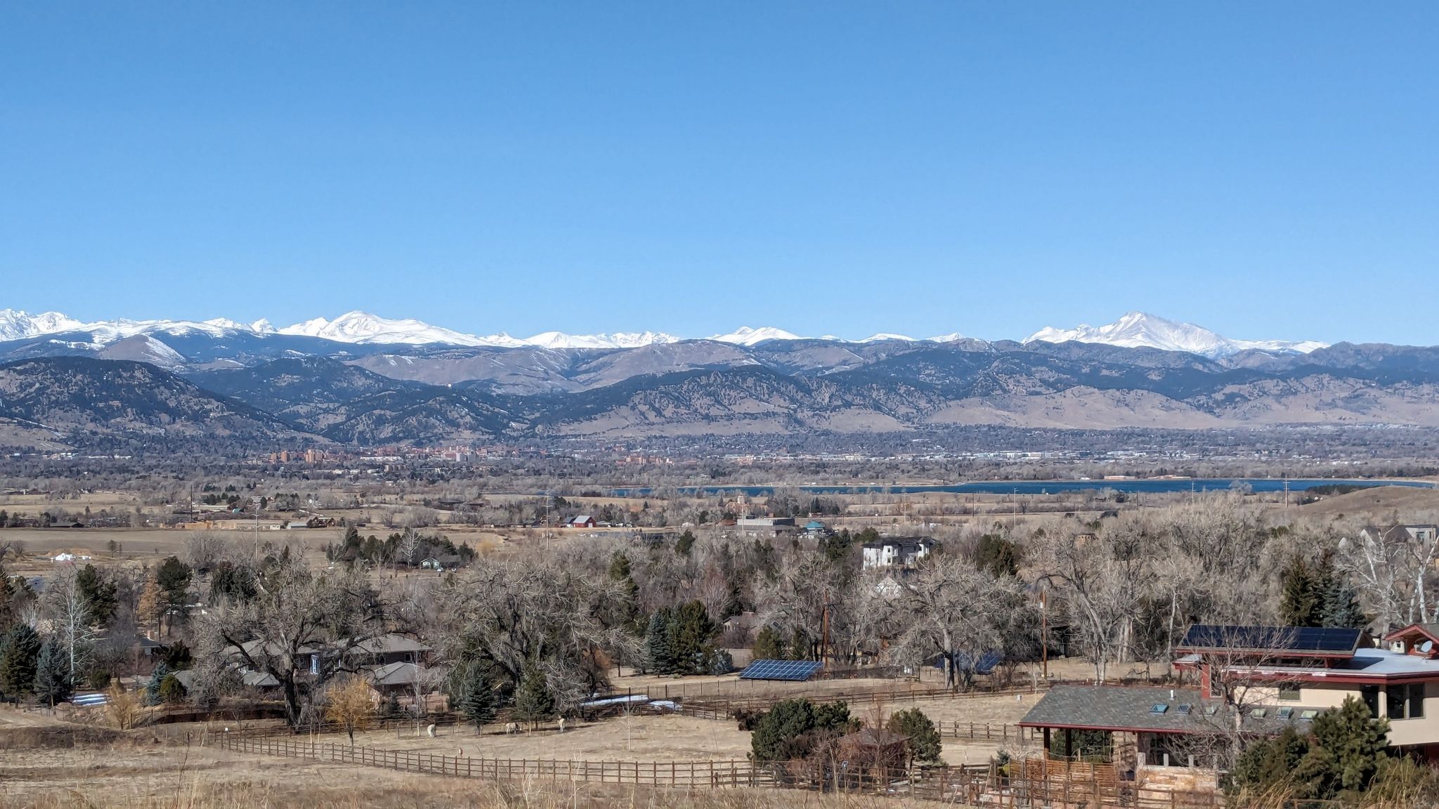 Panoramic view of snow-capped mountains over a distant town under clear sky. - Davidson Mesa Trail – Davidson Mesa loop from Paragon Estates