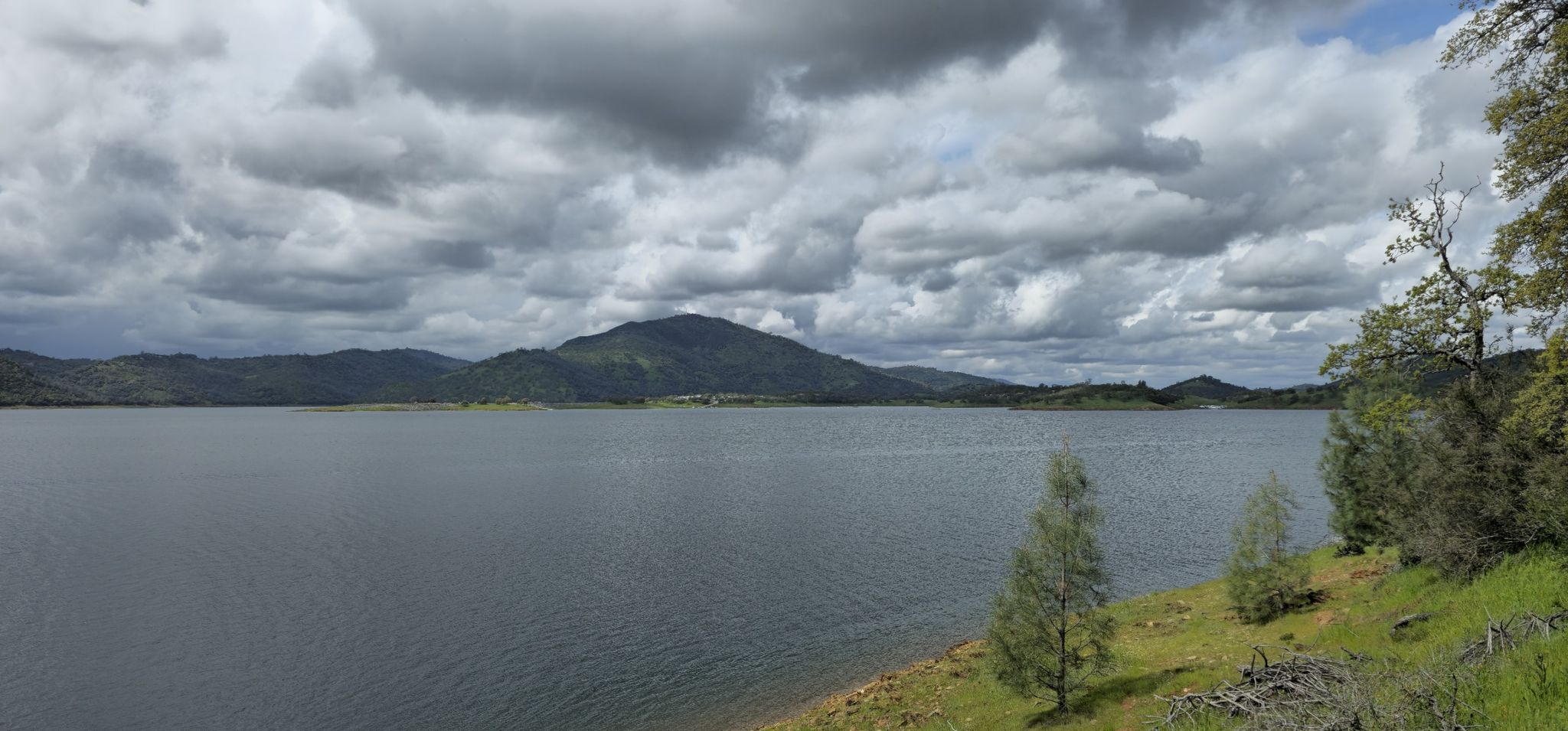 Wide lake with distant mountains under a dramatic cloudy sky. - Heron Point Loop